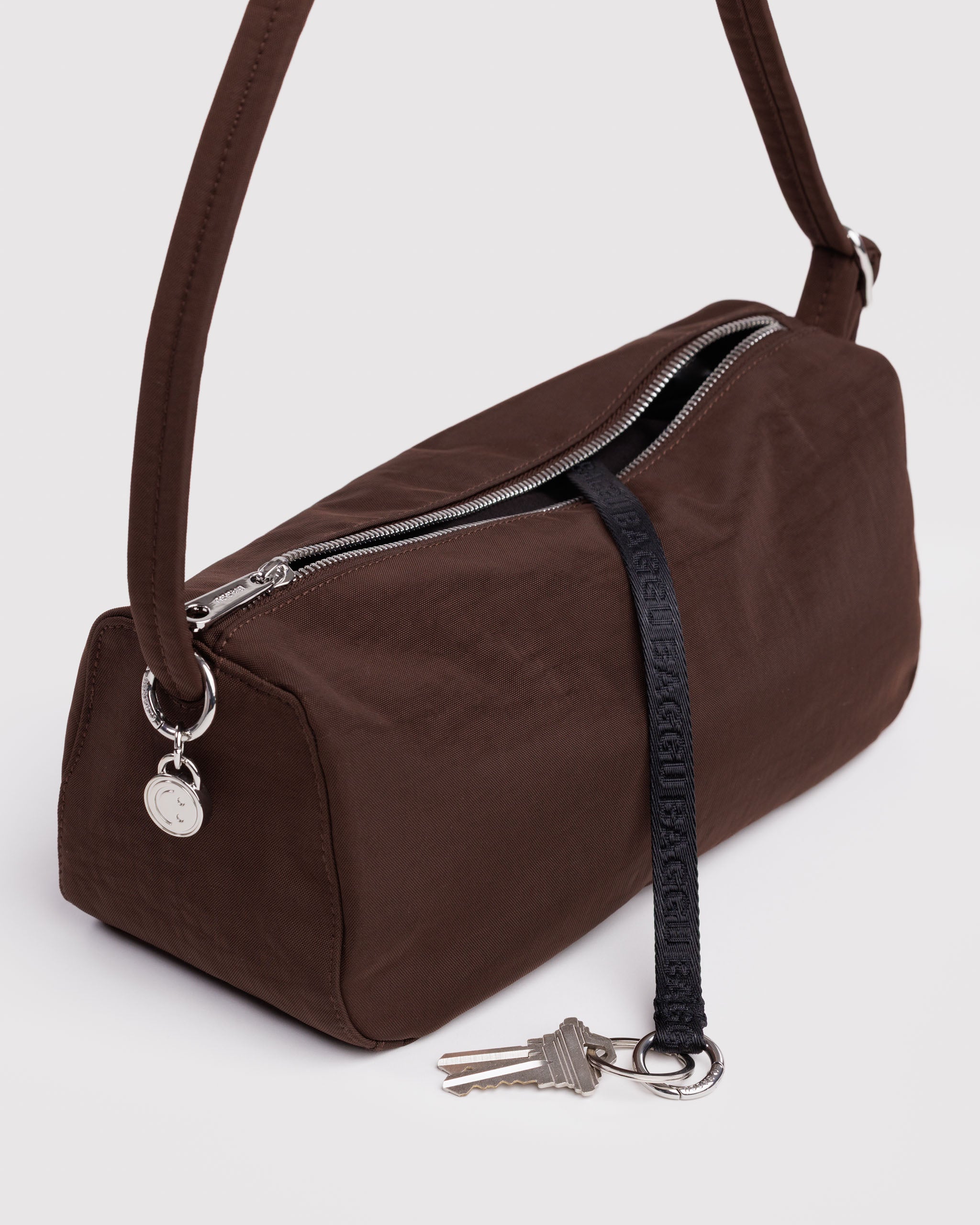 Brown handbag with a keychain on a light gray background