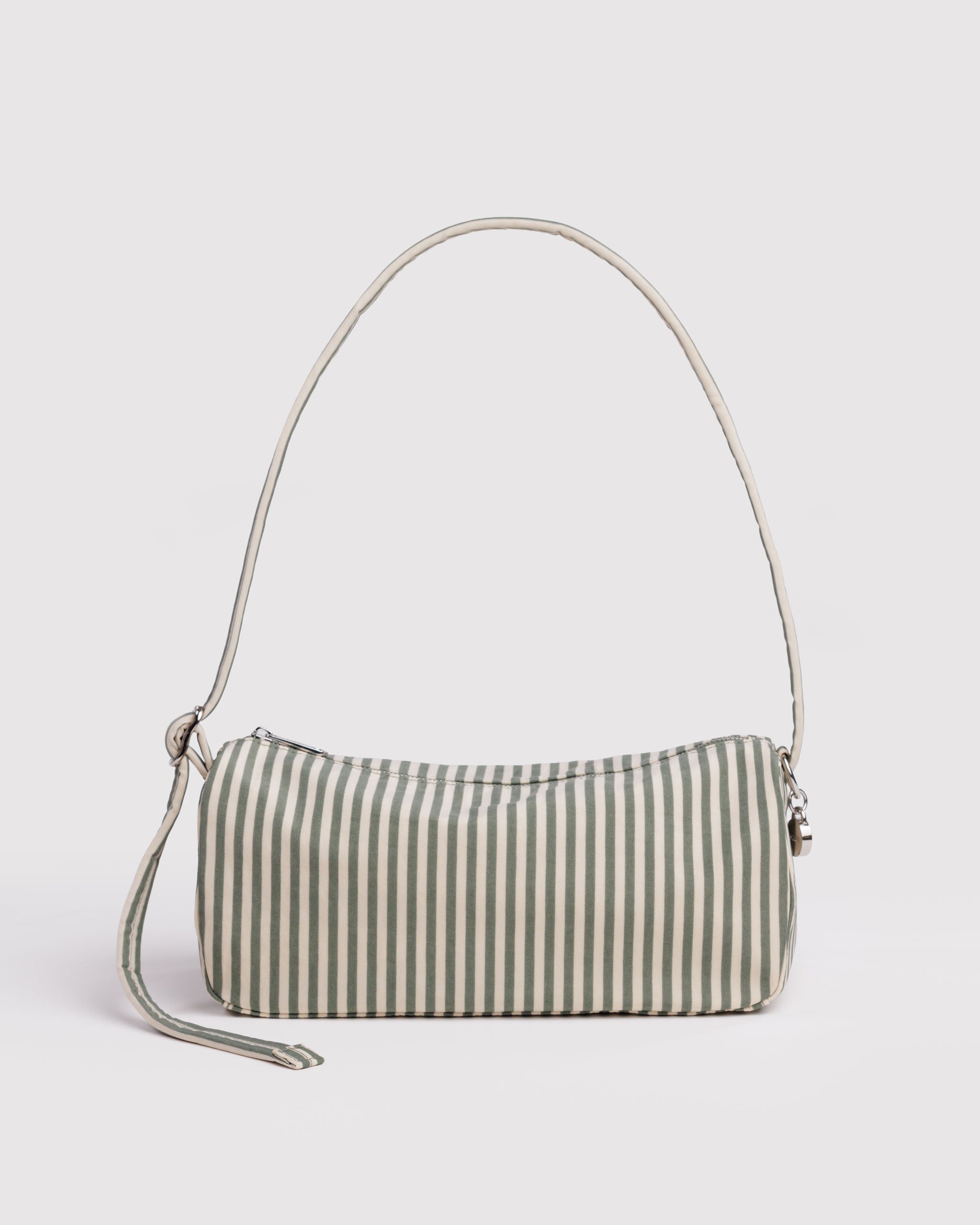 Green and cream striped shoulder handbag with an adjustable strap and zip closure with smiley face charm attached to strap.