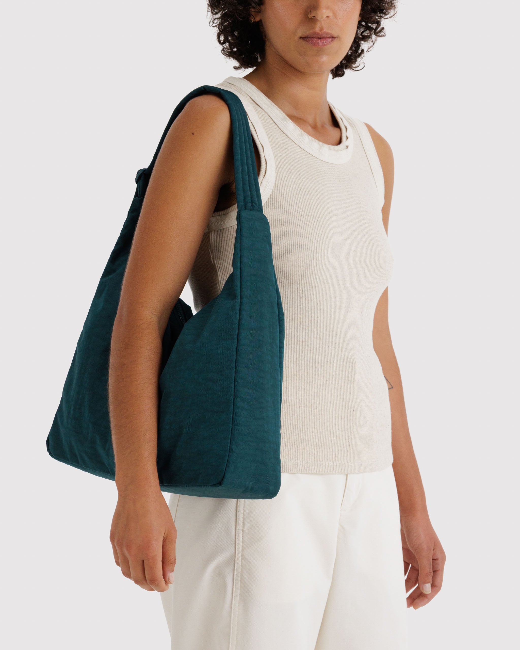 Person carrying a teal handbag on shoulder.