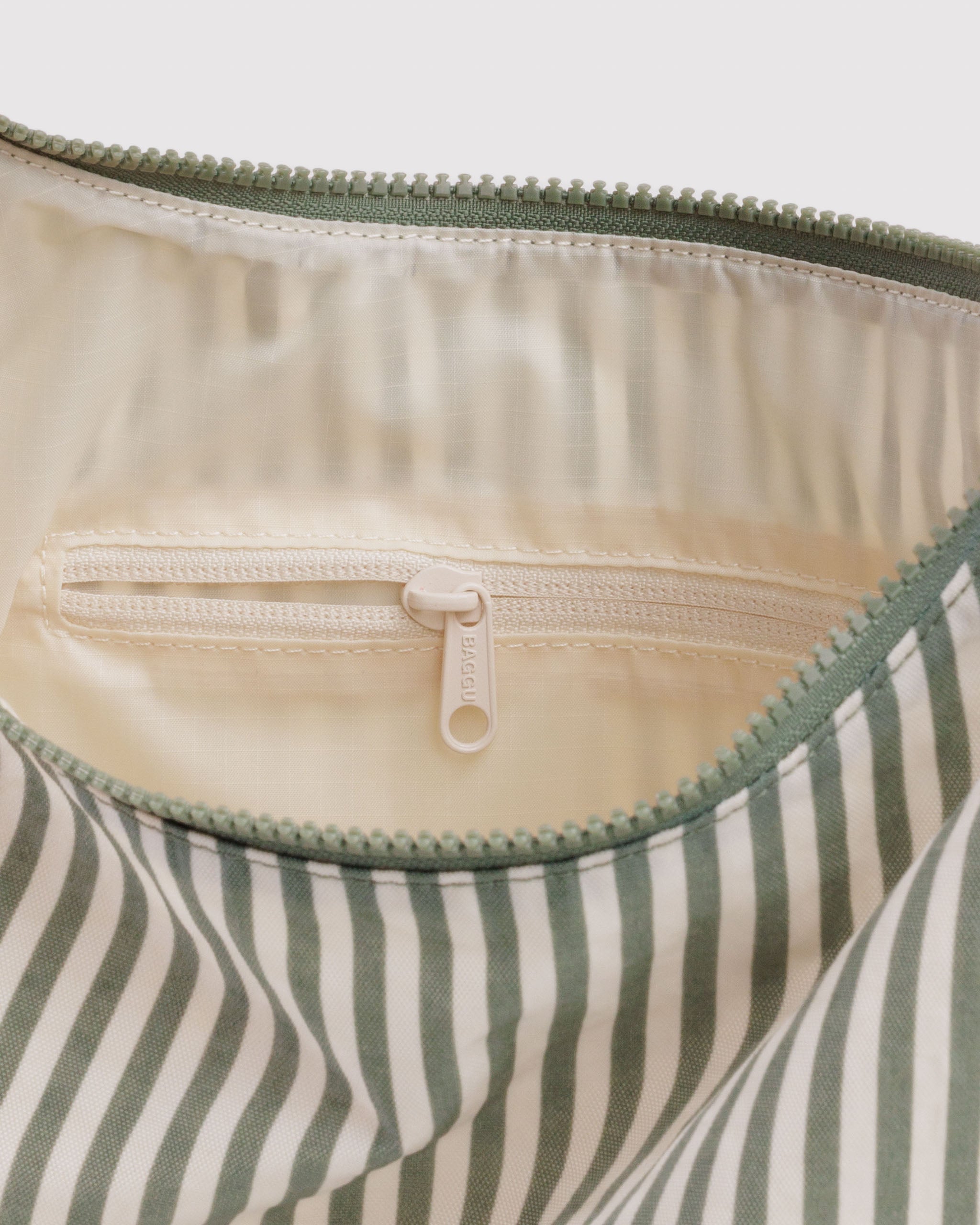 Close-up of a striped bag with a zipper, showing the inside lining and zip pocket.