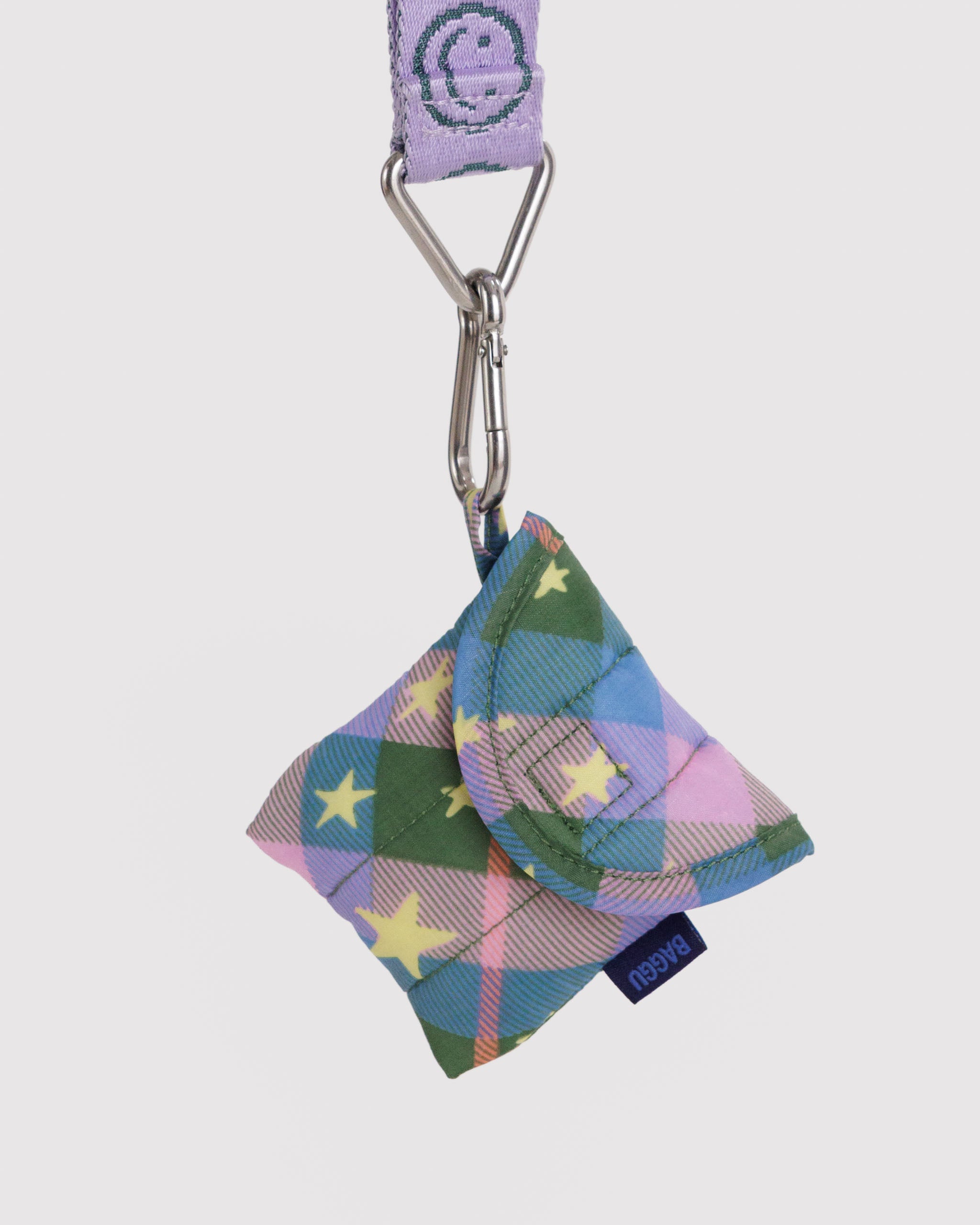Green plaid earbuds pouch with star patterns attached by side loop to a carabiner on lilac happy face keychain.