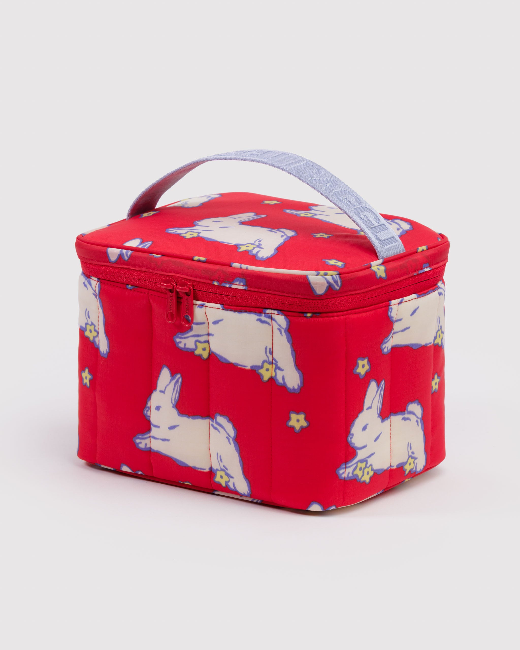 Red puffy and quilted lunch bag with white rabbit pattern, zip closure nad carry handle.