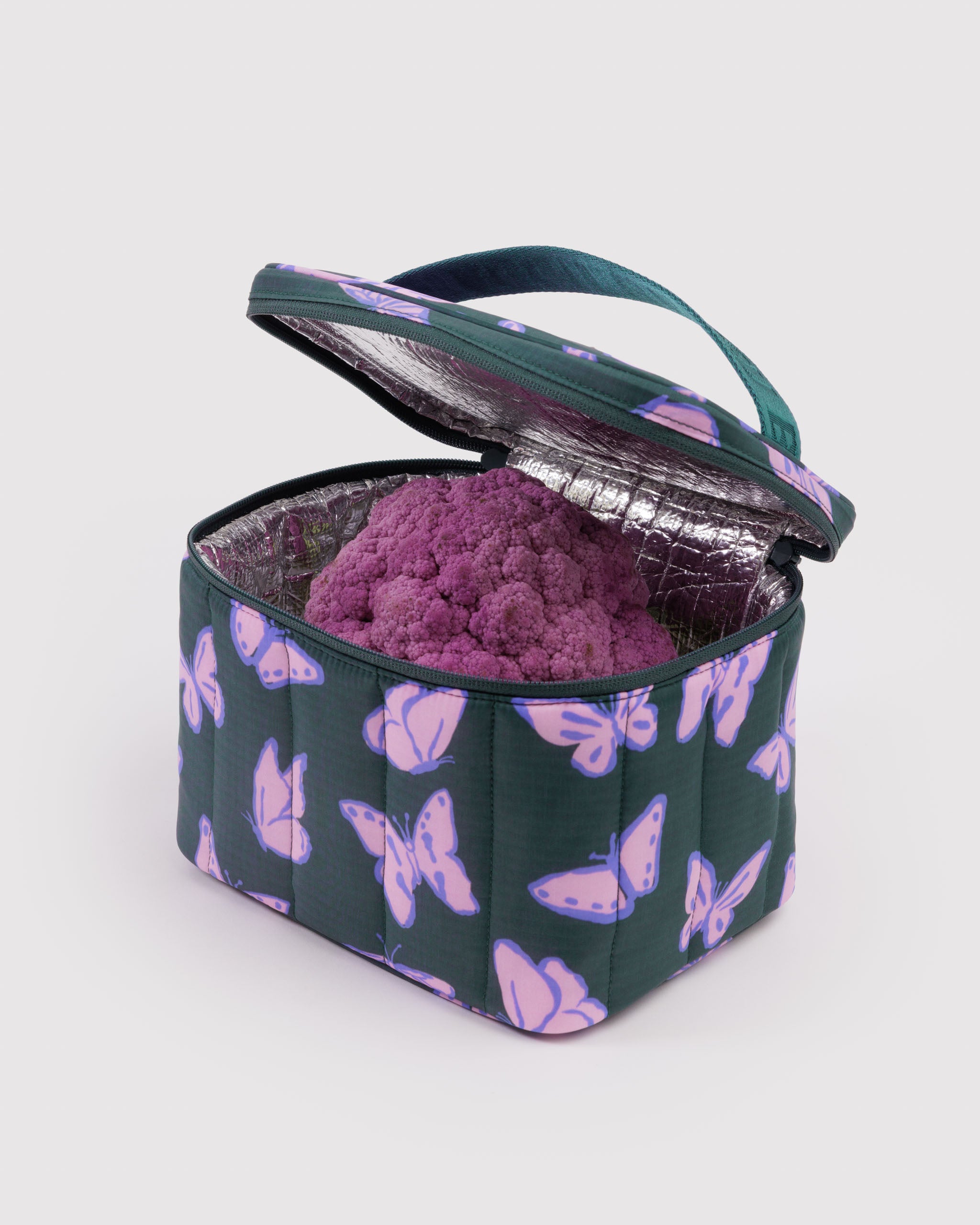 Green insulated lunch bag with purple butterfly pattern with zip top open and containing a purple cauliflower.