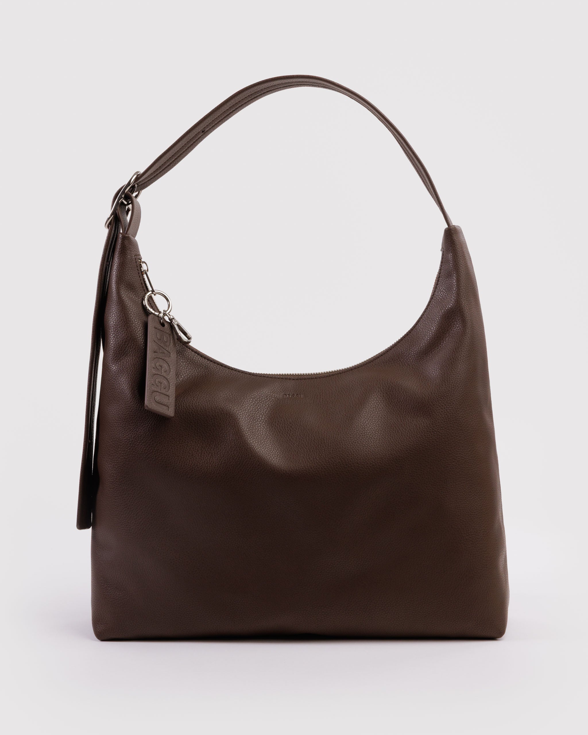 Brown leather handbag with adjustable strap and a BAGGU brand tag and silver clip attached to zipper pull.