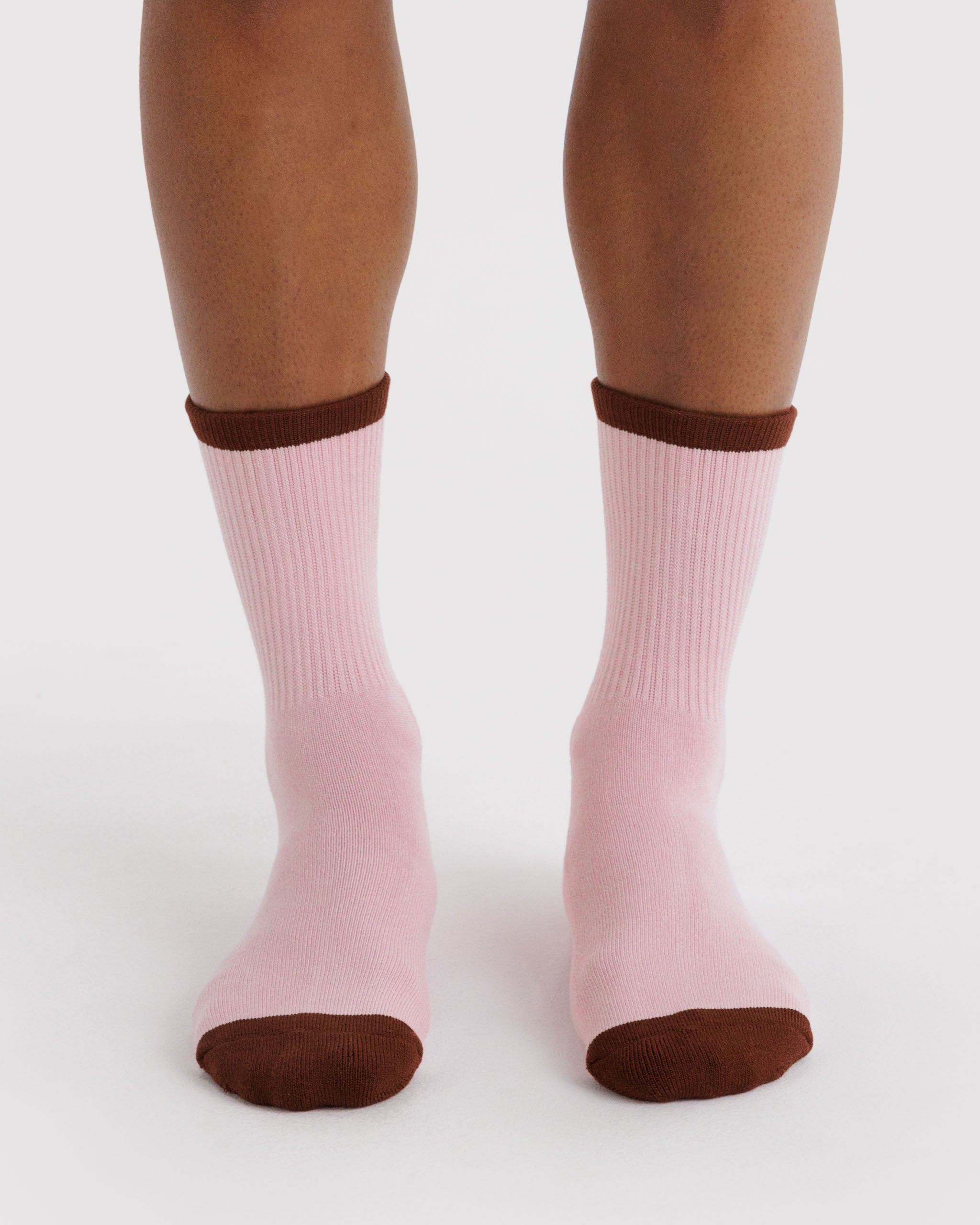 Pink ribbed socks with brown toes and cuffs worn by a person.