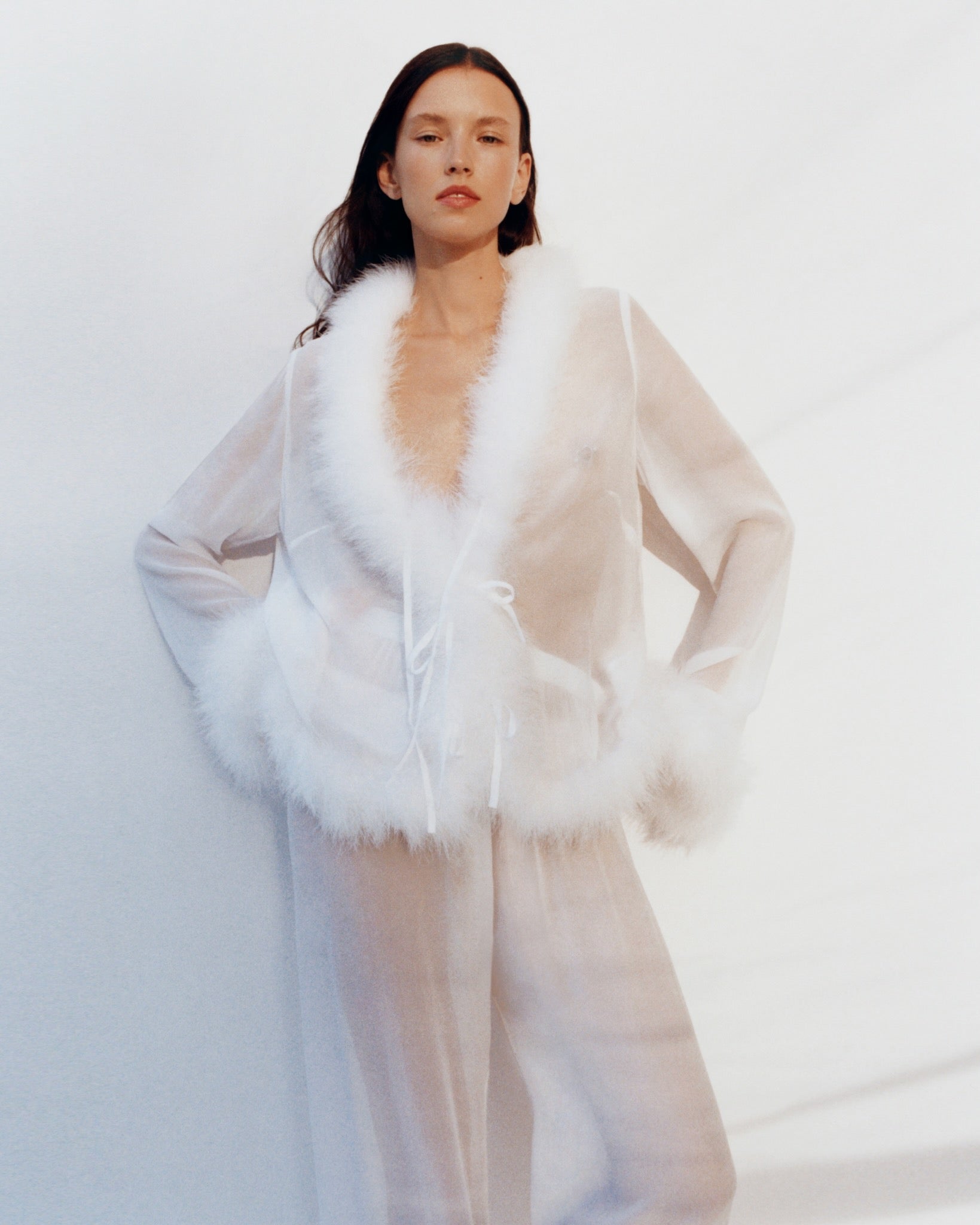 front-of-woman-wearing-afrodita-lounge-pants-and-shirt-set-in-white-with-feathers-and-bow-tie-closure