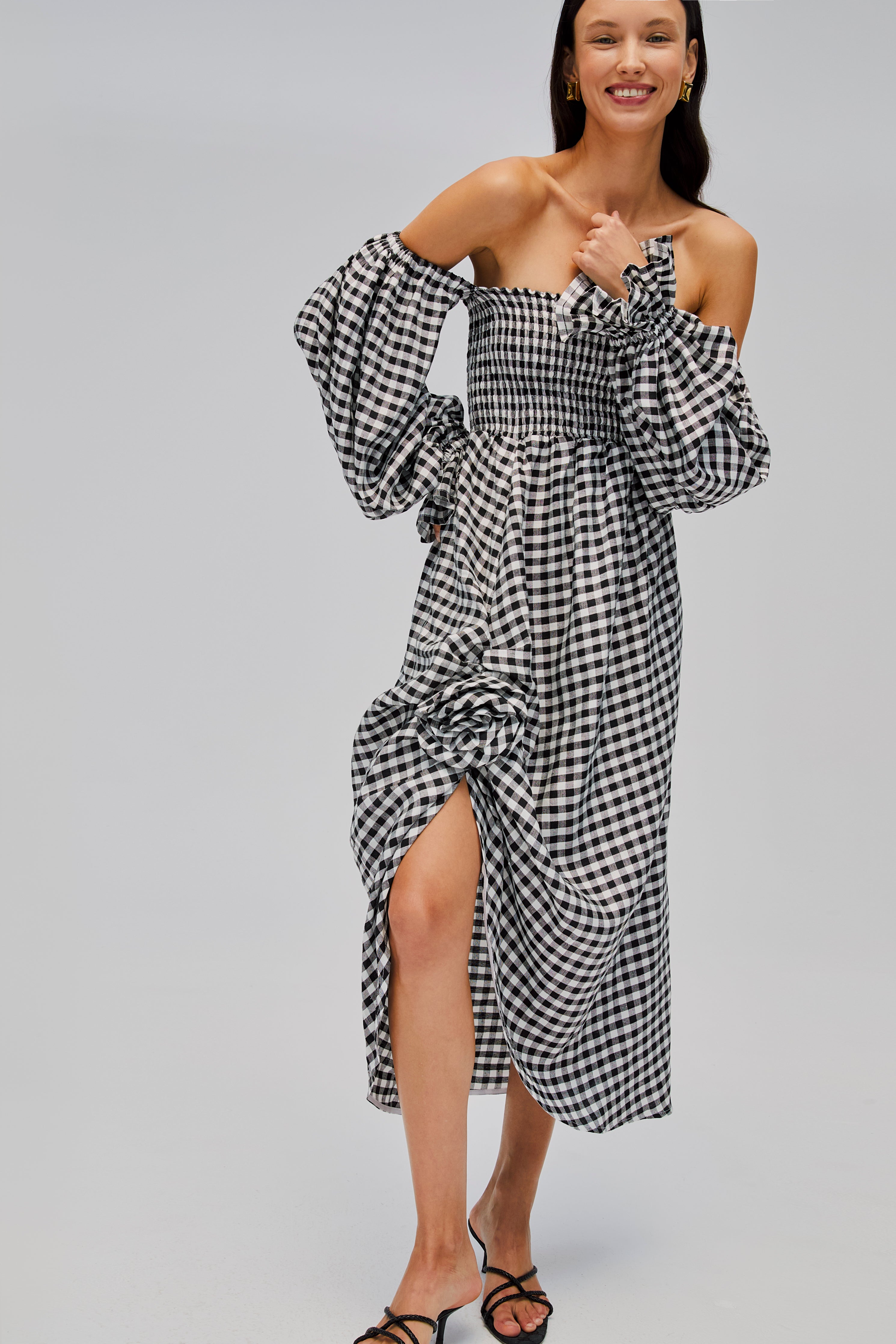 woman-wearing-black-gingham-smock-bodice-dress-showing-long-sleeve-cuff-and-rose-above-front-split-detail
