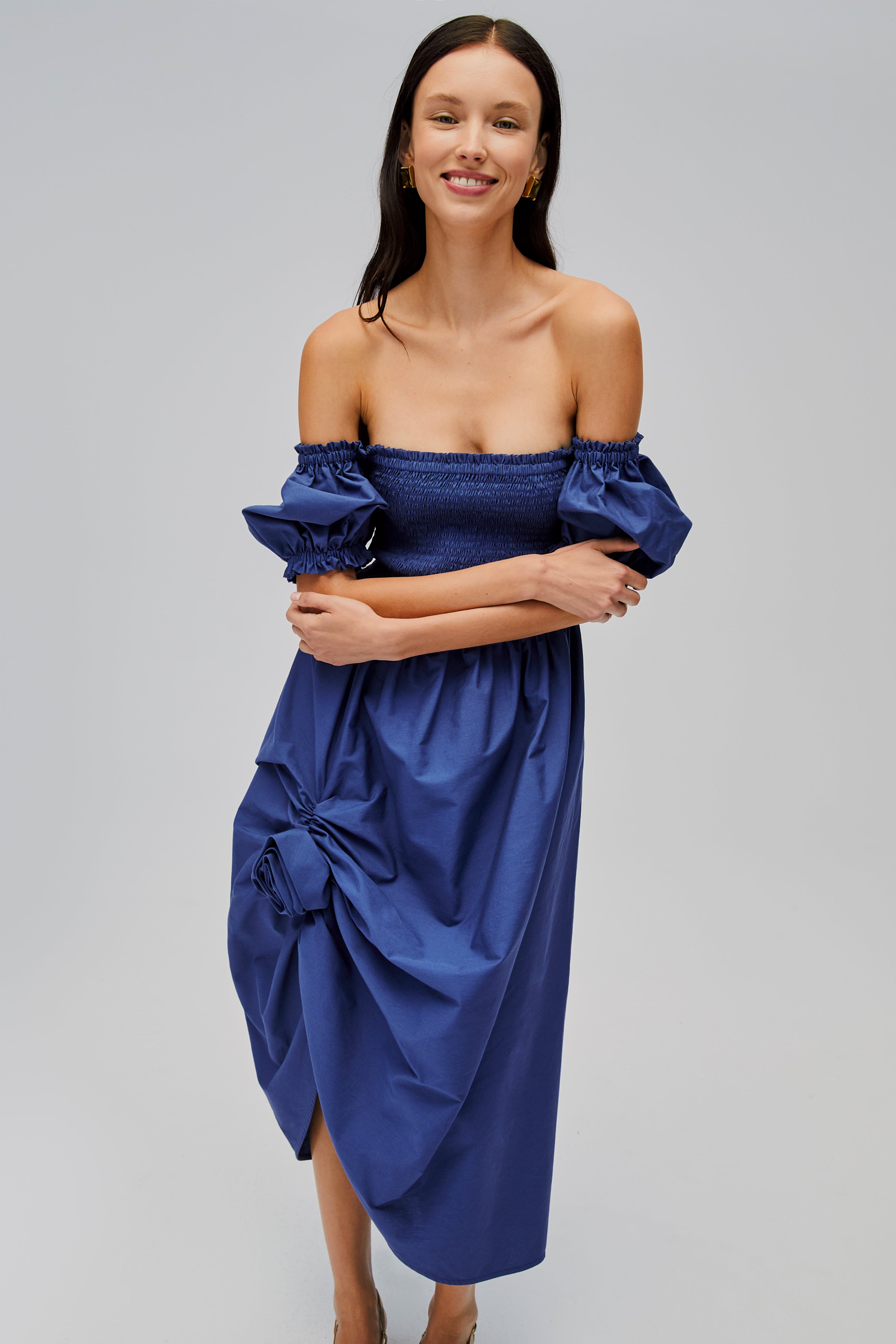 woman-wearing-navy-shirred-bodice-dress-with-short-sleeves-off-the-shoulder-arms-folded-in-front
