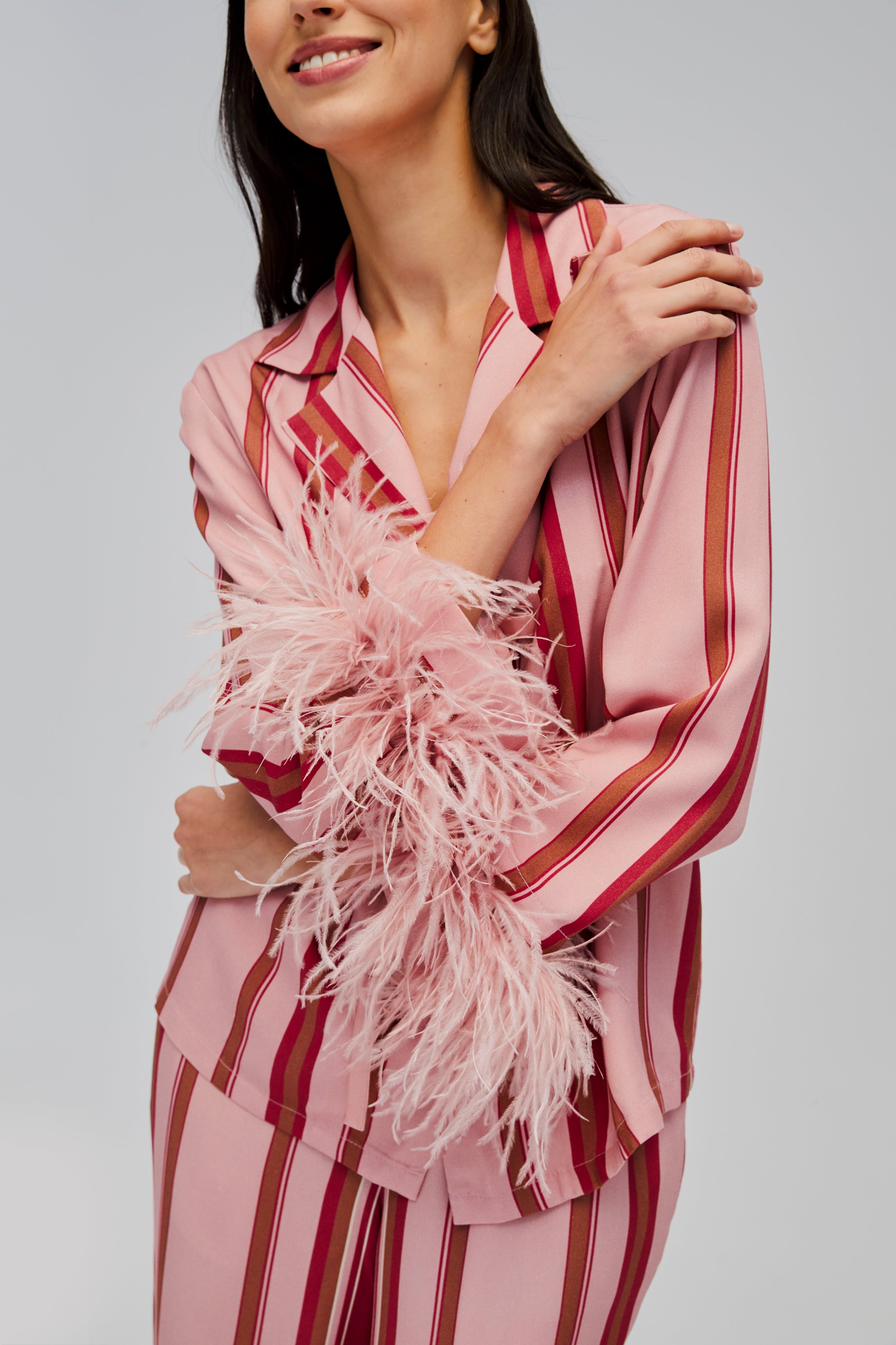 closeup-of-pink-feather-cuffs-on-pink-and-red-striped-shirt