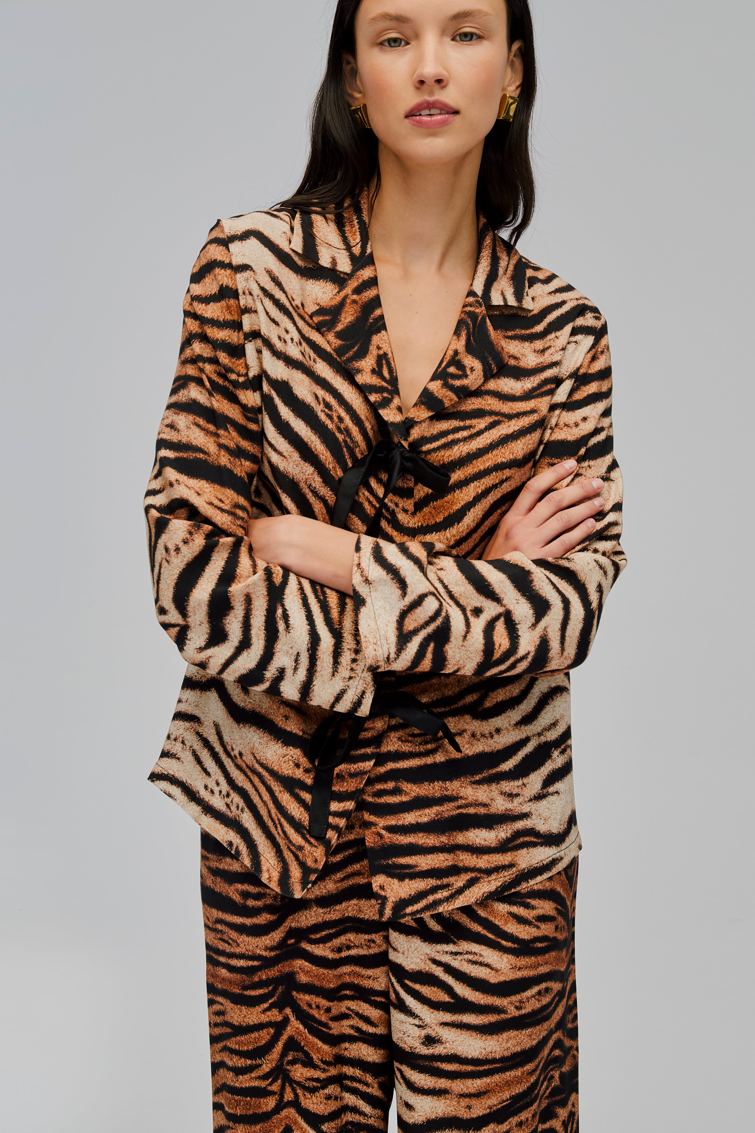 woman-wearing-tiger-print-pyjama-long-sleeve-shirt-and-pants-three-bow-ties-with-arms-crossed