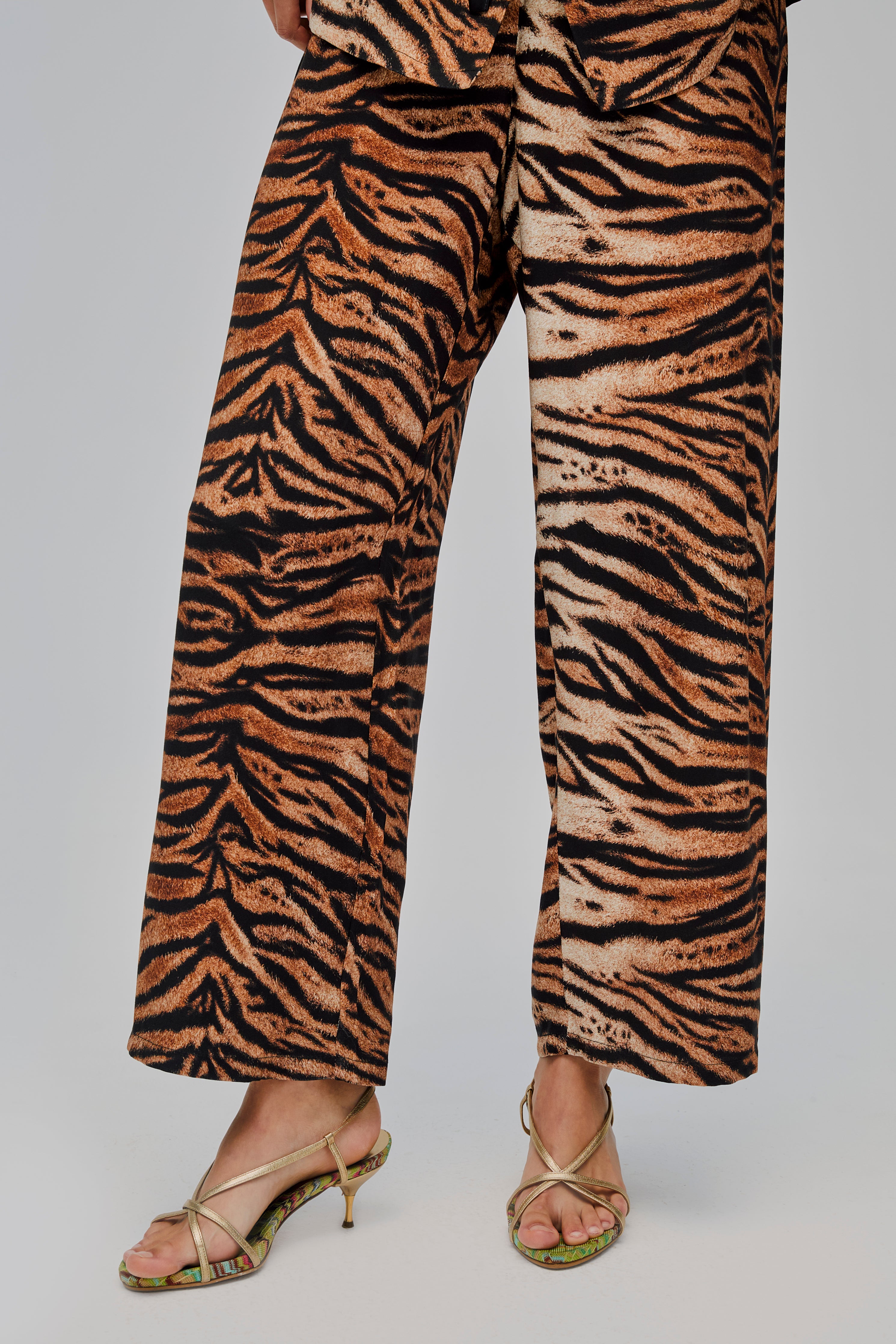 close-up-of-woman-wearing-tiger-print-pyjama-long-pants-and-gold-sandals