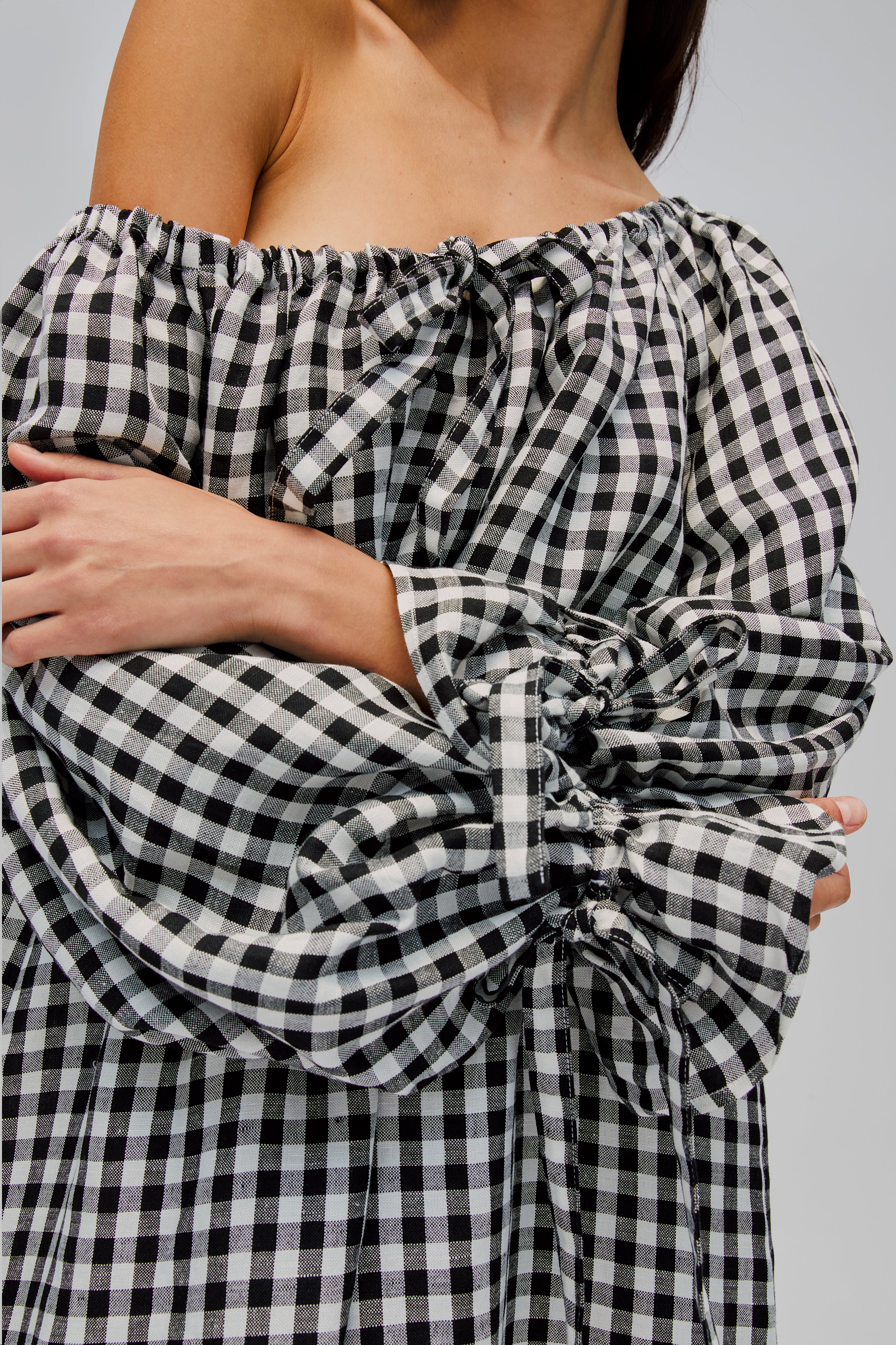 closeup-of-woman-wearing-black-gingham-off-shoulder-dress-with-long-sleeves