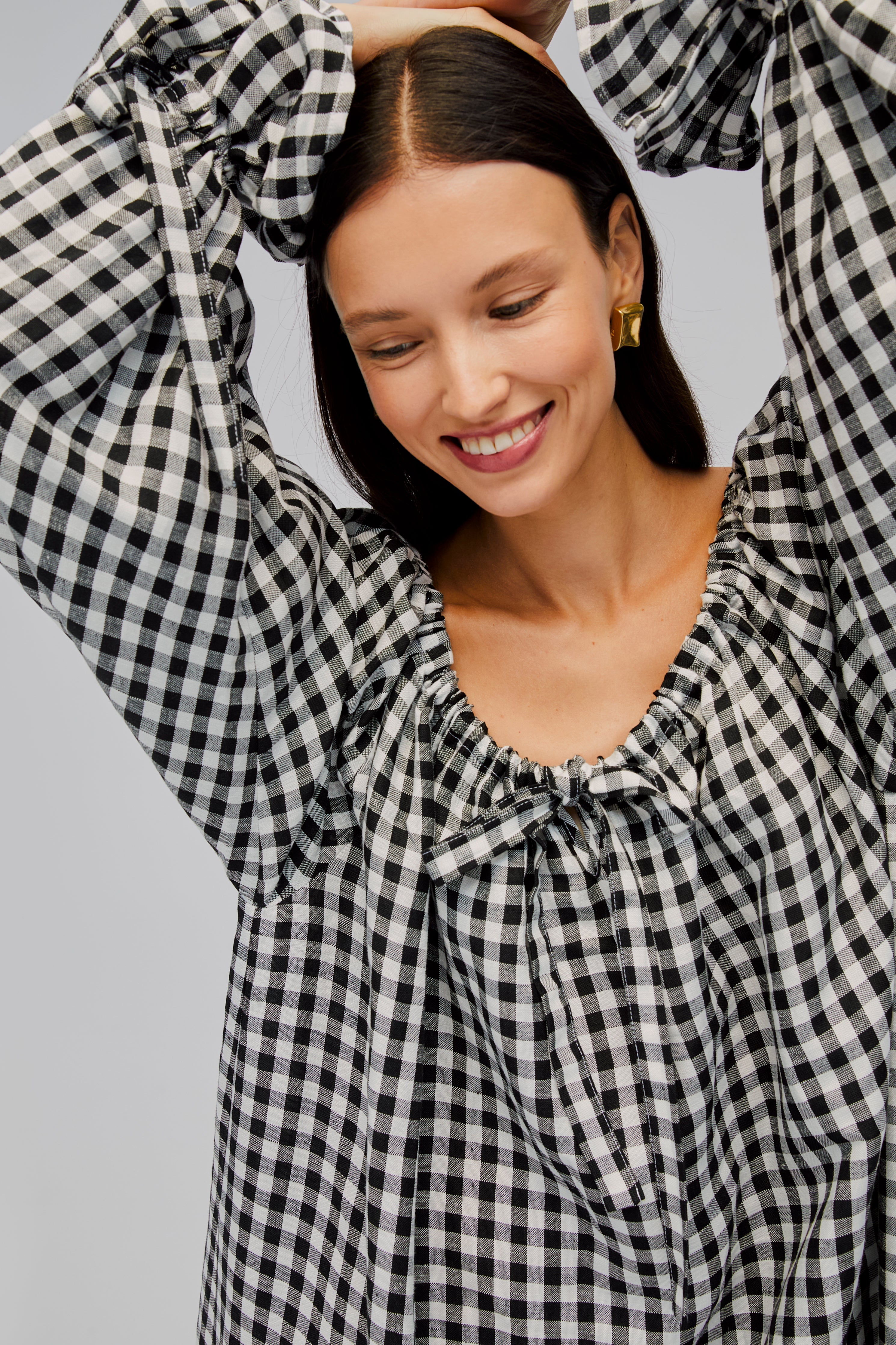 closeup-of-woman-wearing-black-gingham-dress-showing-tie-neckline-and-long-sleeves-cuffs