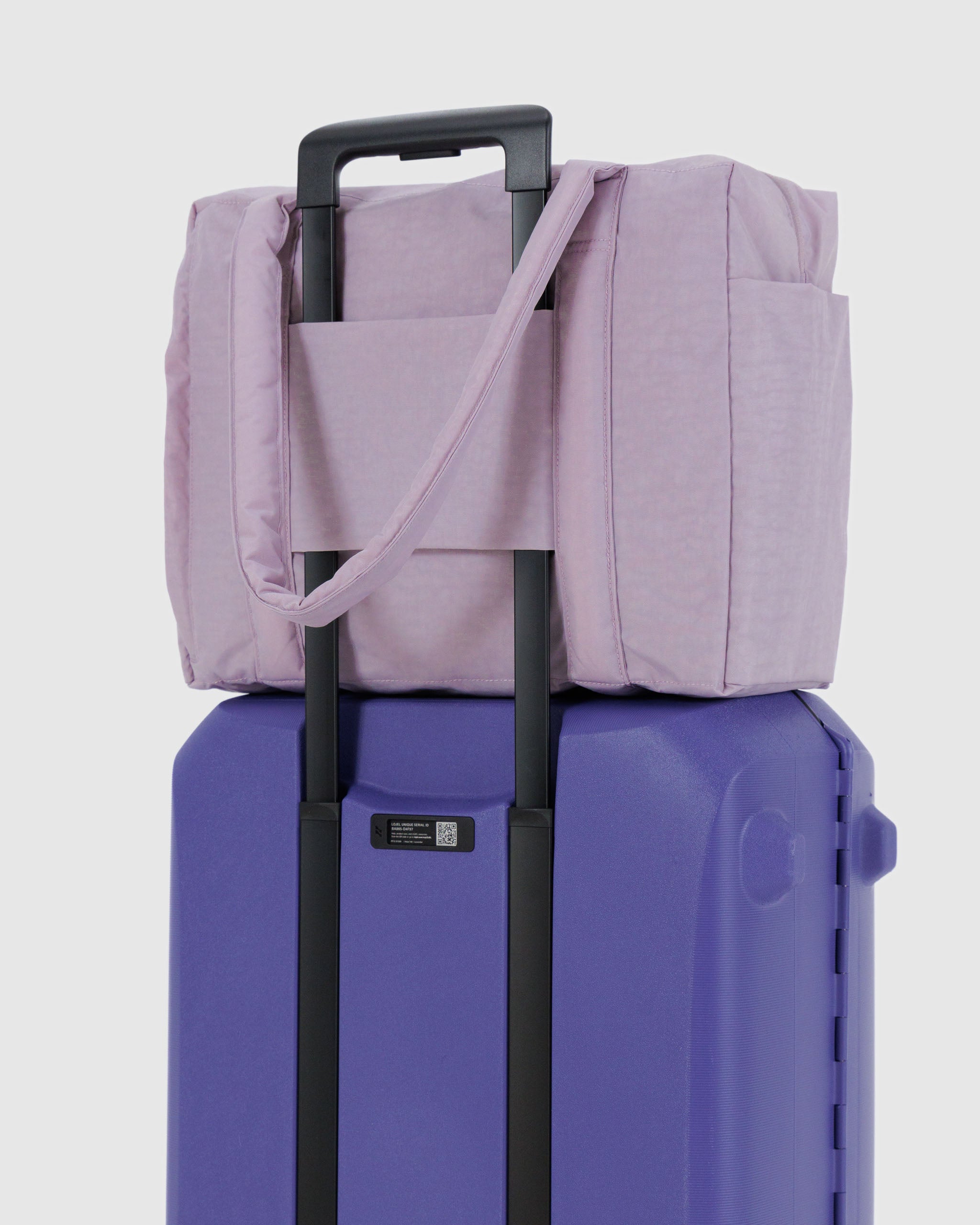 dusty-pink-small-cloud-carry-on-travel-sleeve-attached-to-purple-suitcase