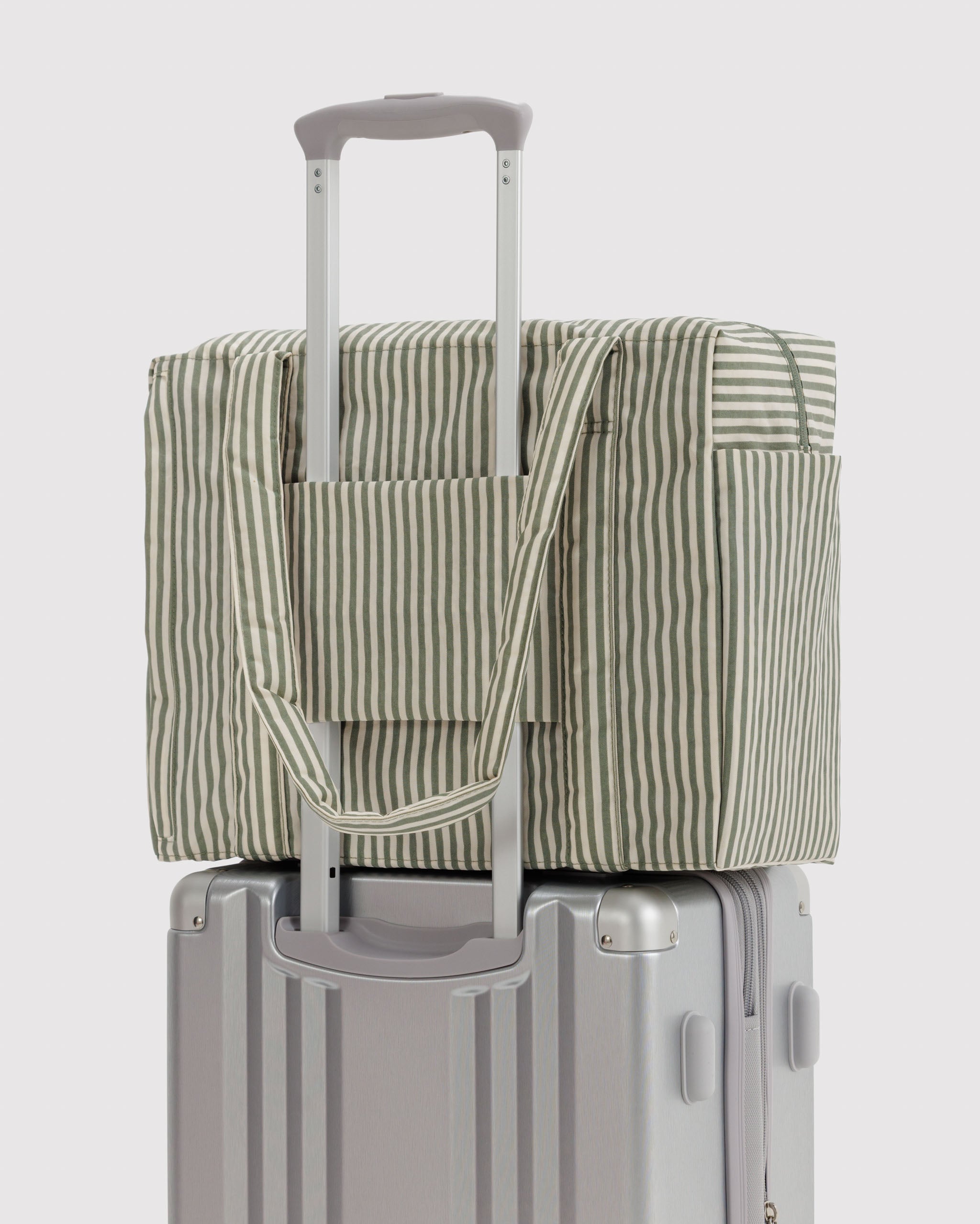 Striped tote cover on a grey suitcase attached with trolley sleeve