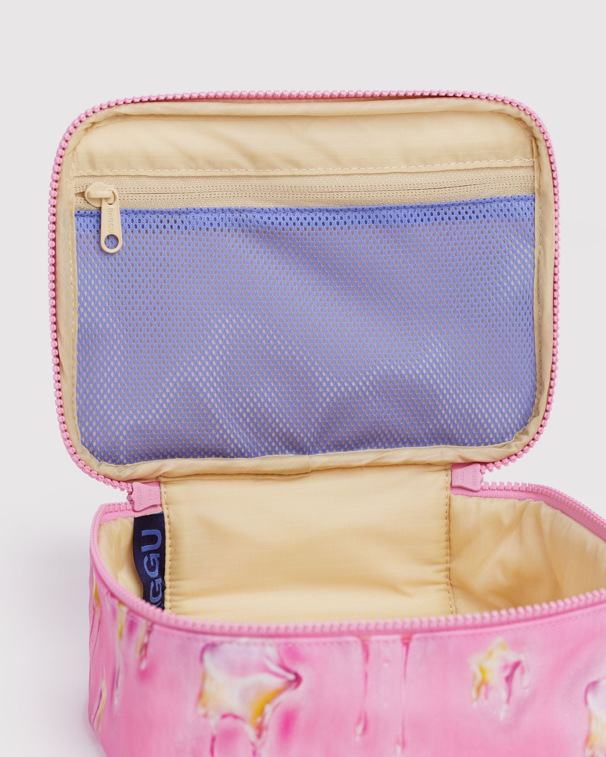 Pink cosmetic bag with yellow stars pattern and open zipper showing purple mesh zip pocket