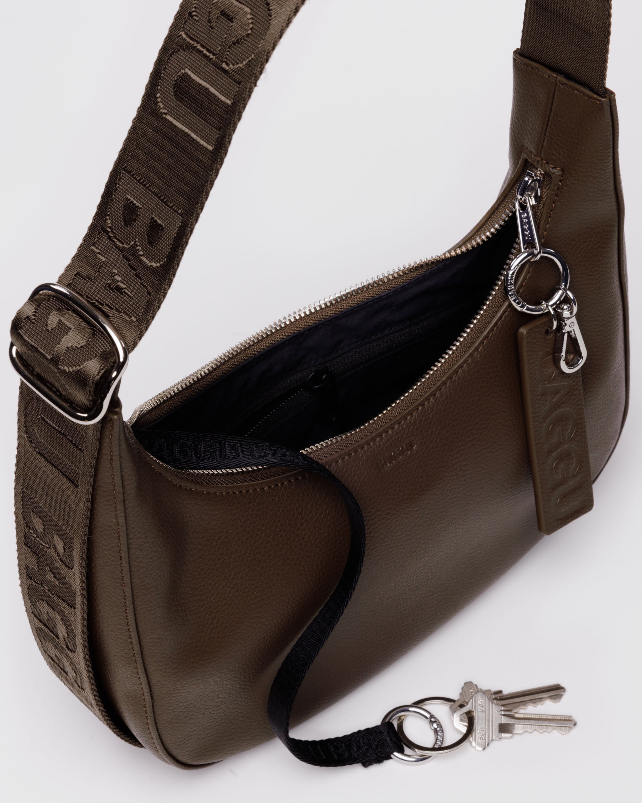 brown-recycled-leather-crescent-bag-logo-strap-with-zip-open-showing-keyleash