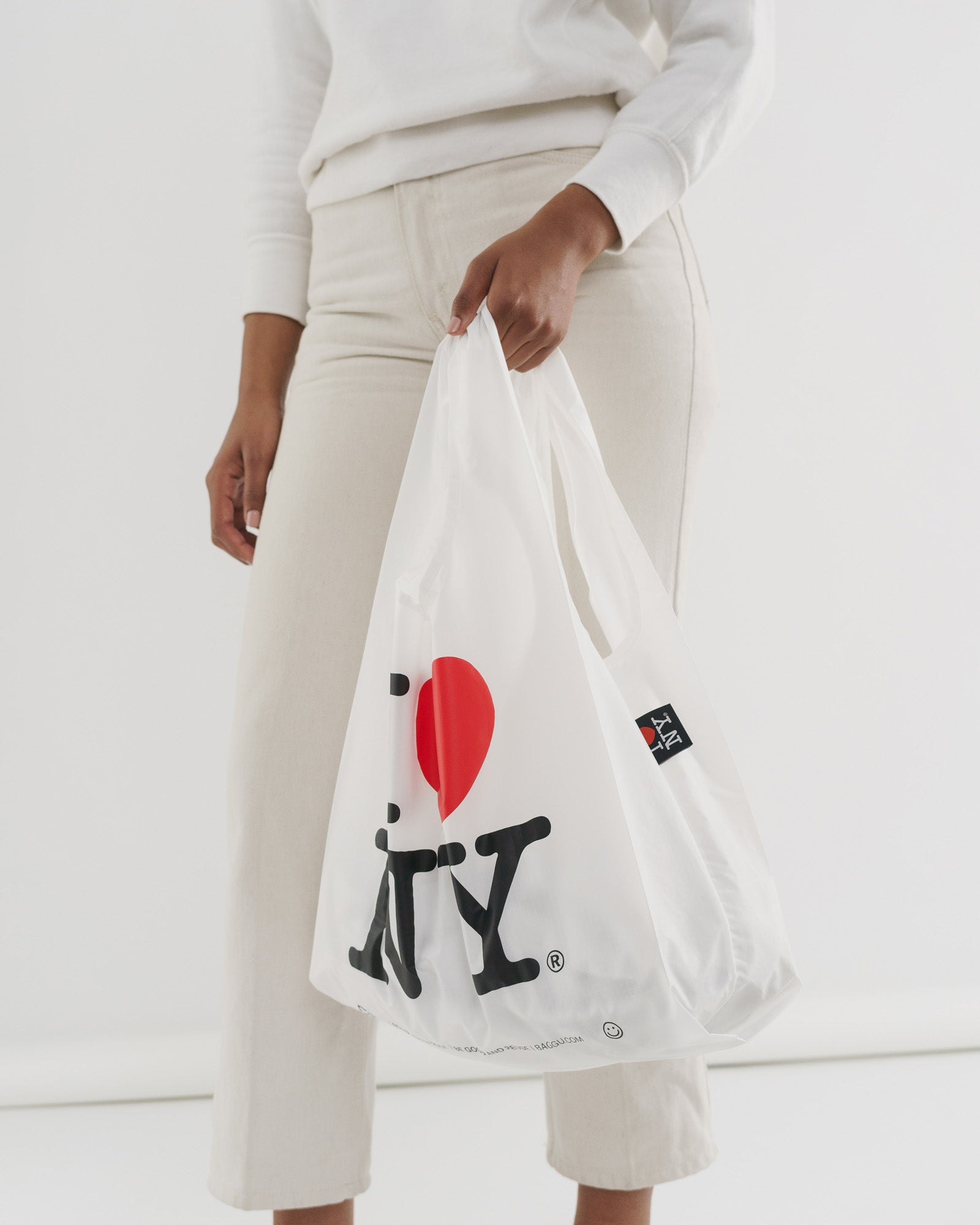 Woman-holding-in-hand-Baggu-standard-bag-in-white-and-I-Love-NY