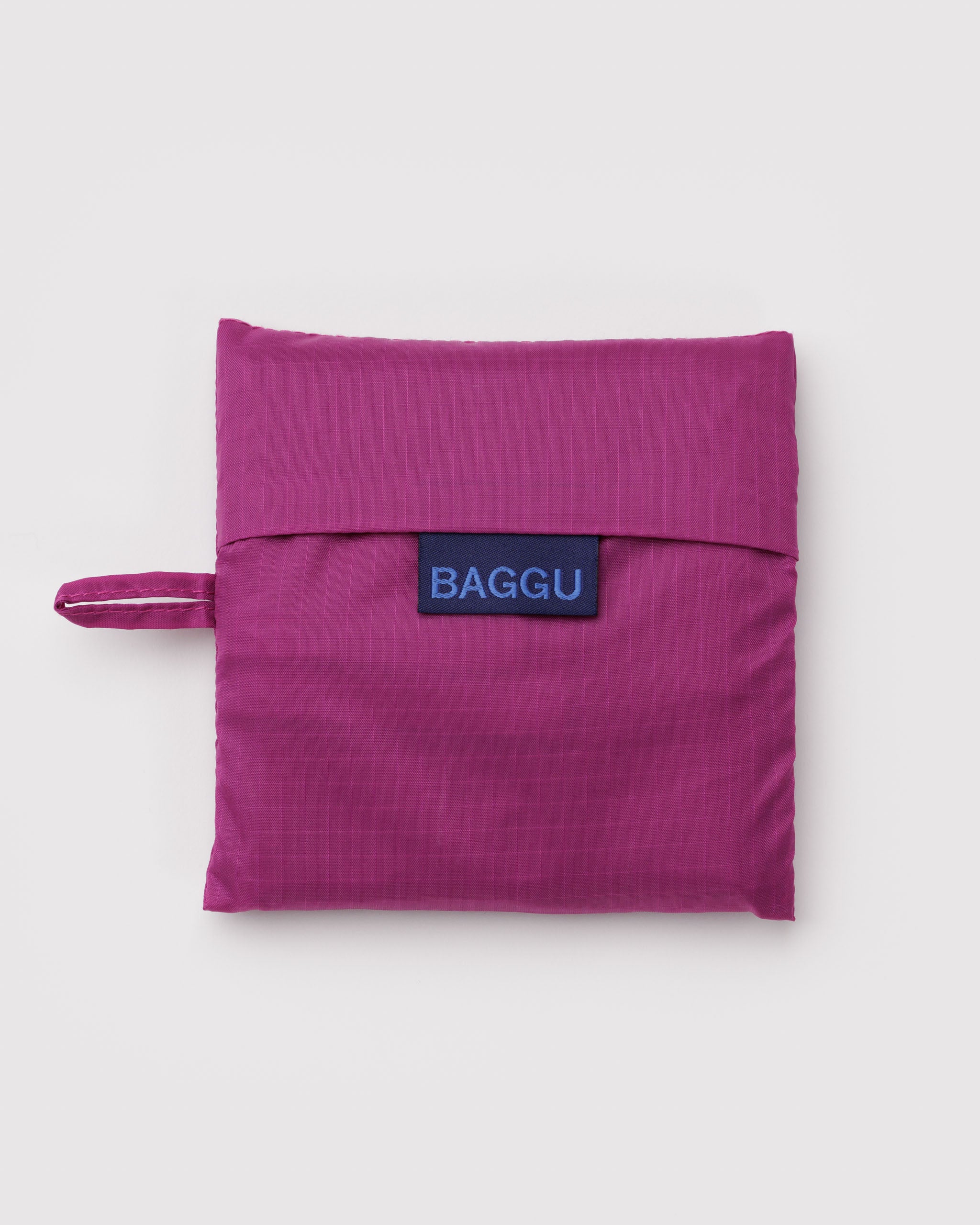 Vibrant pink pouch with 'BAGGU' logo with hanging loop.