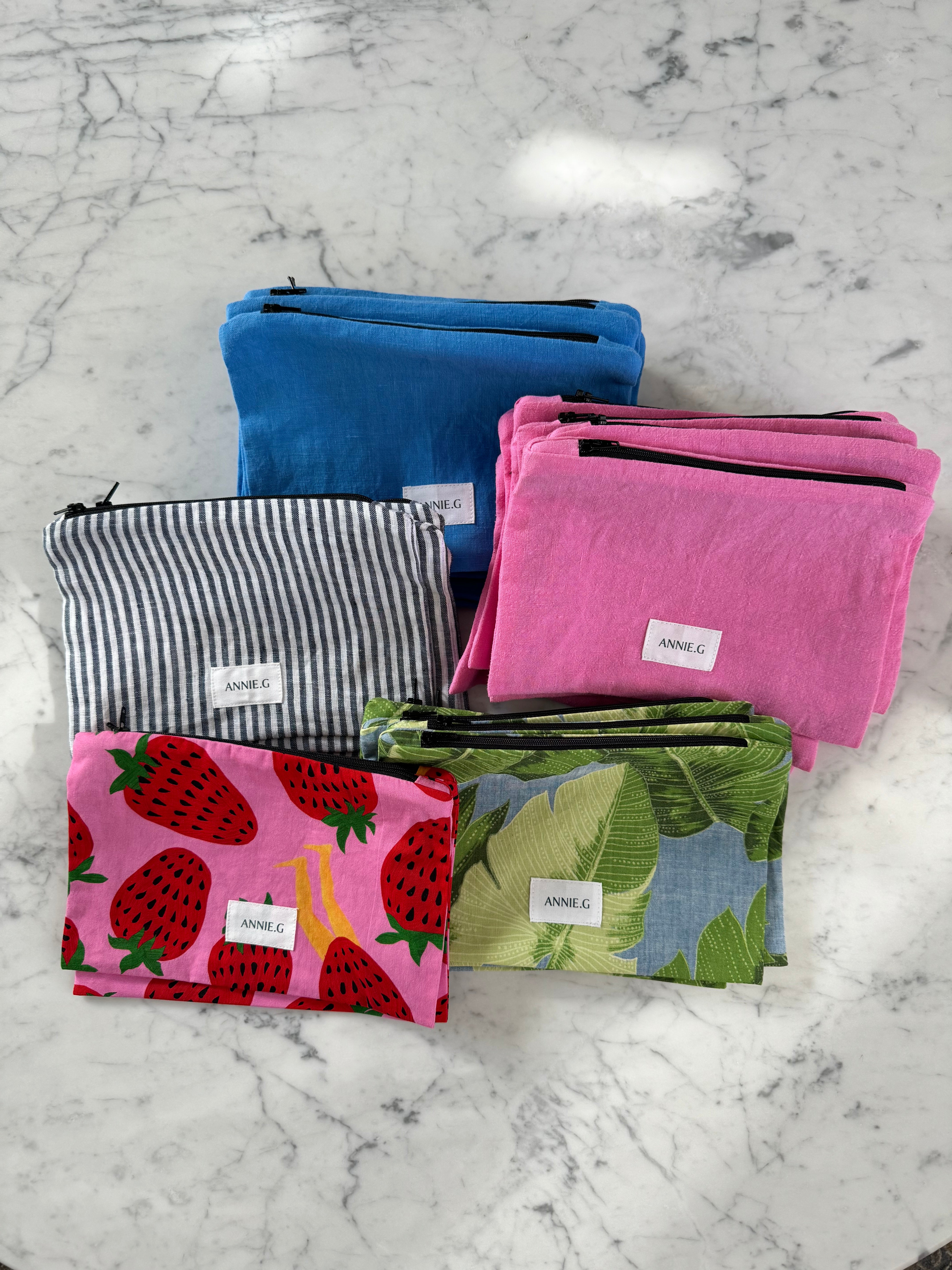 ZIPPER-POUCH-LYING-IN-A-GROUP-ON-TABLE-SWEET-LEGS-QLD-NAVY-STRIPE-BLUE-PINK-COLOURS