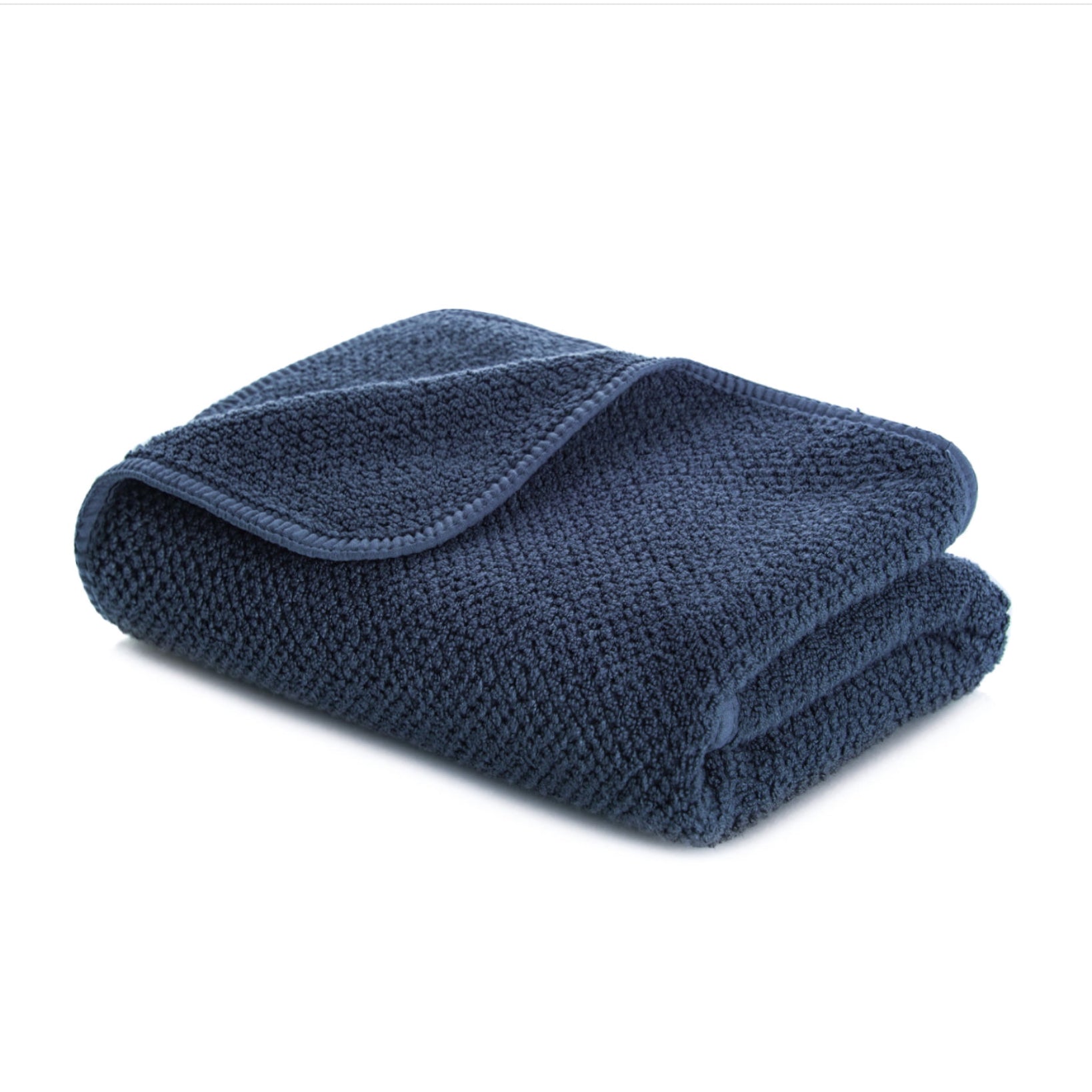 Folded navy blue waffle textured hand towel with rounded corners and bias binding edge.