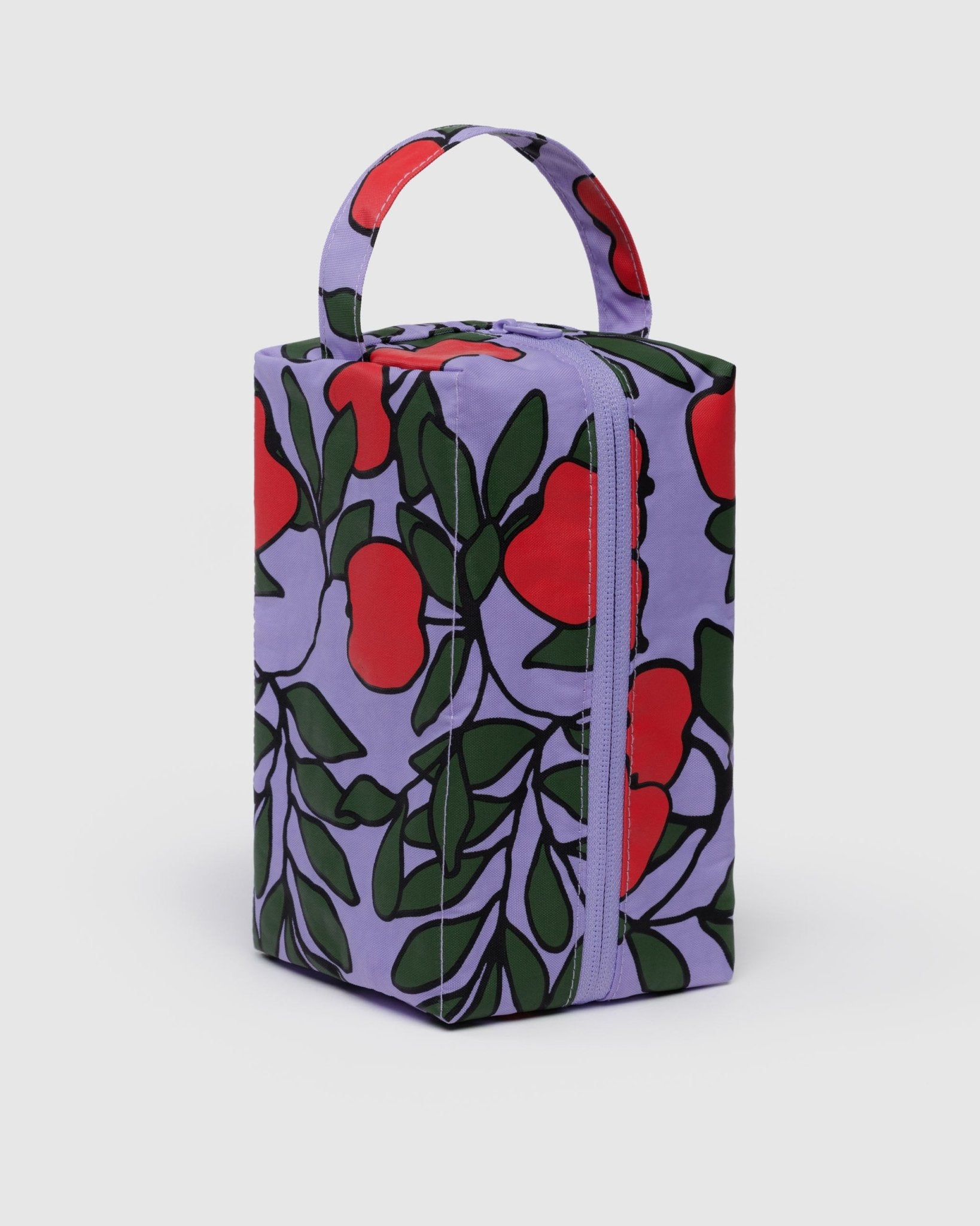 red apples and green leaves print on purple background of toiletry bag with handle and zip
