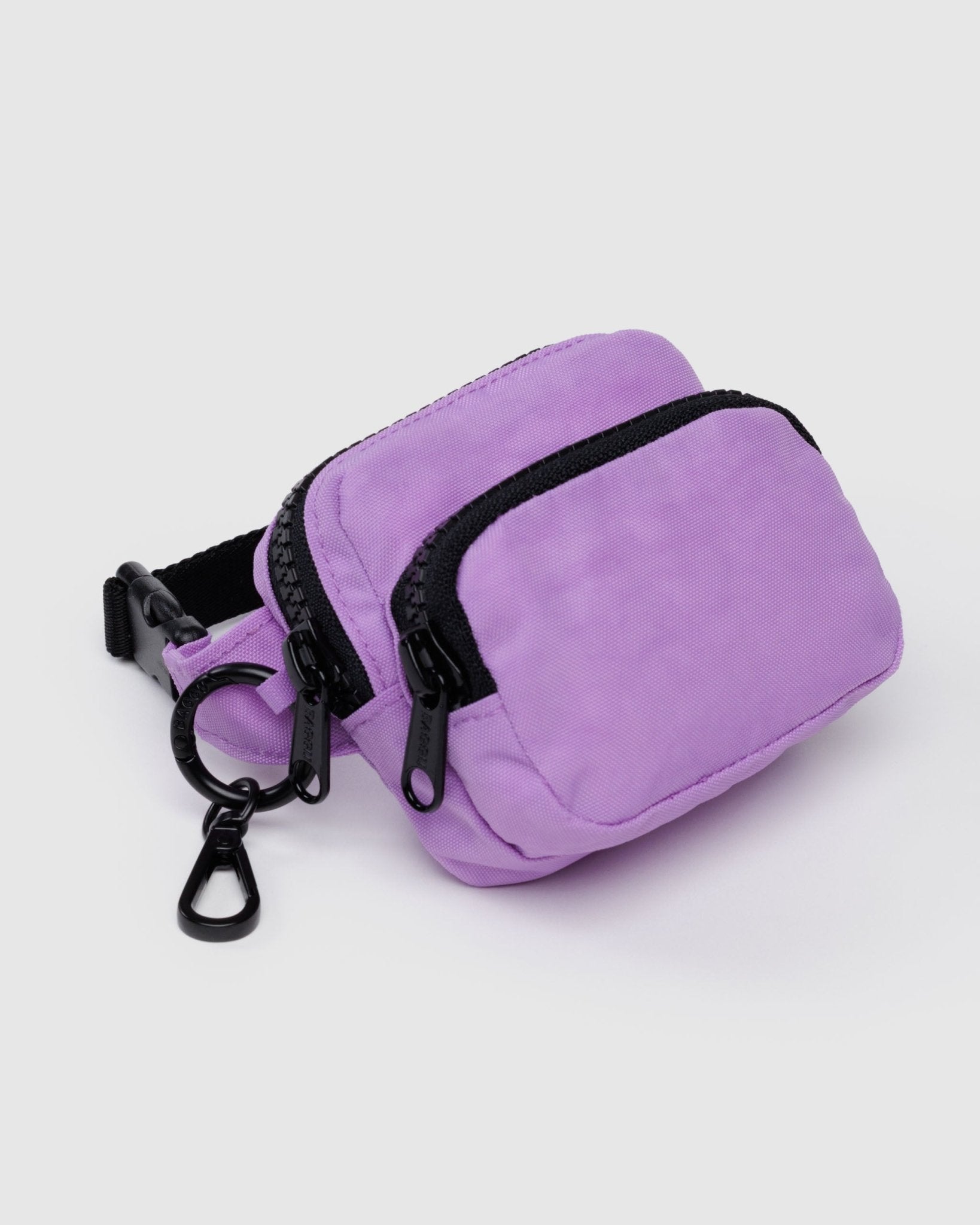 Small purple fanny pack charm with two black zippered pockets, clip and black adjustable strap