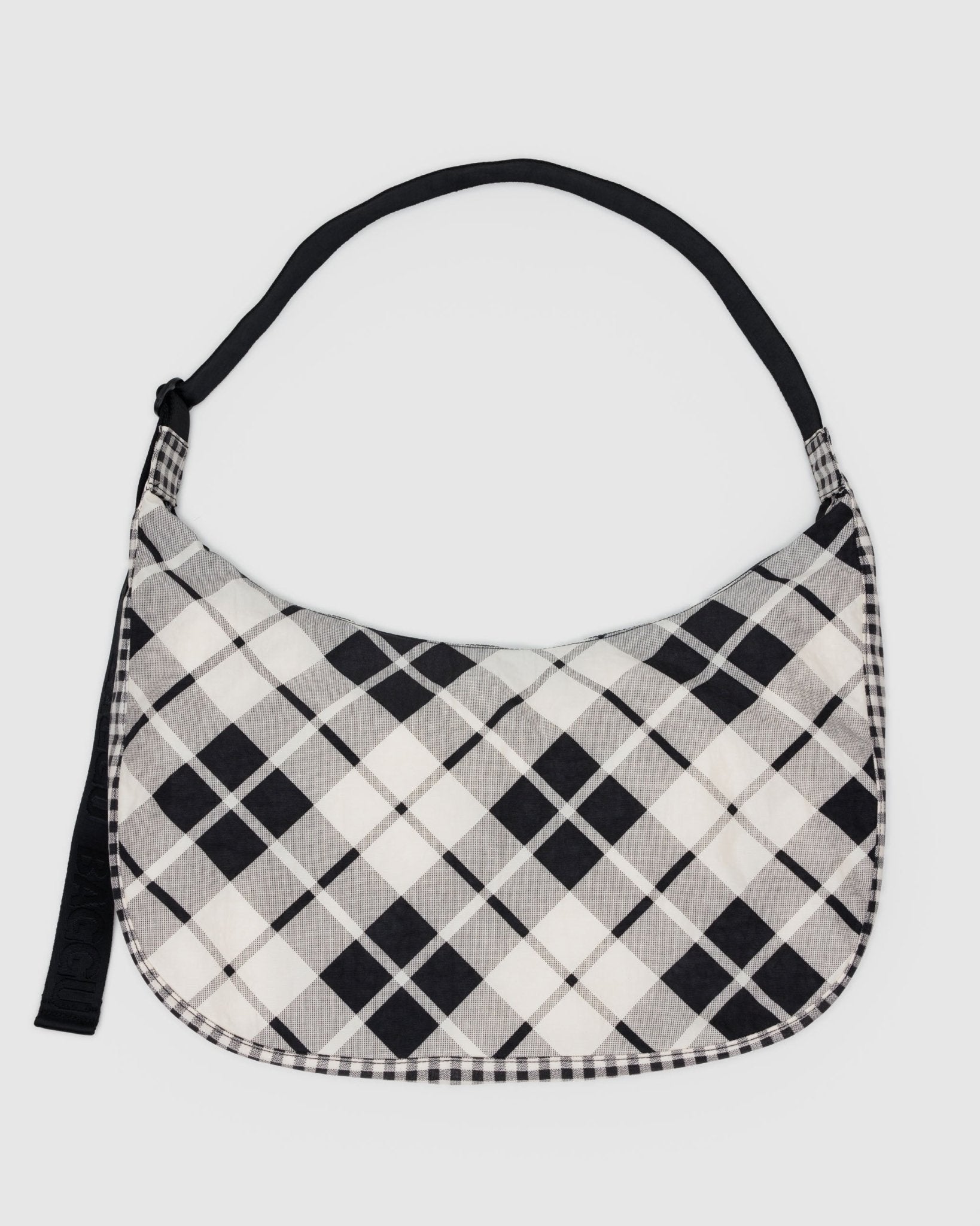 Black and white plaid patterned bag with black adjustable strap and zip closure