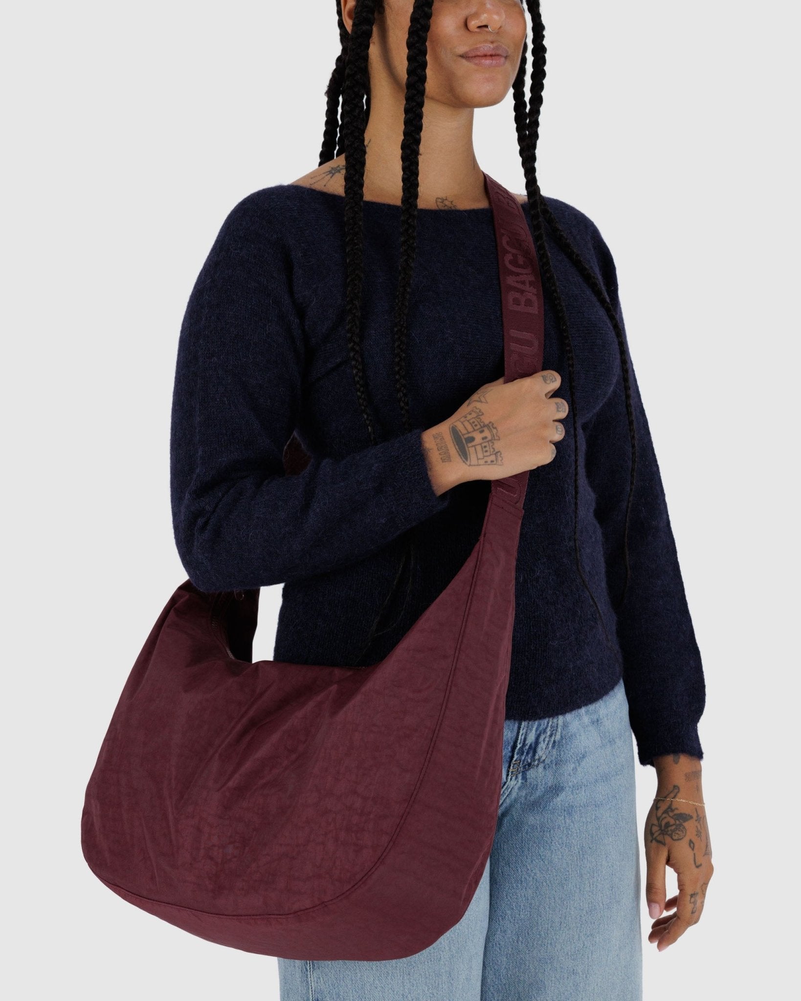 Person holding a large maroon bag crossbody