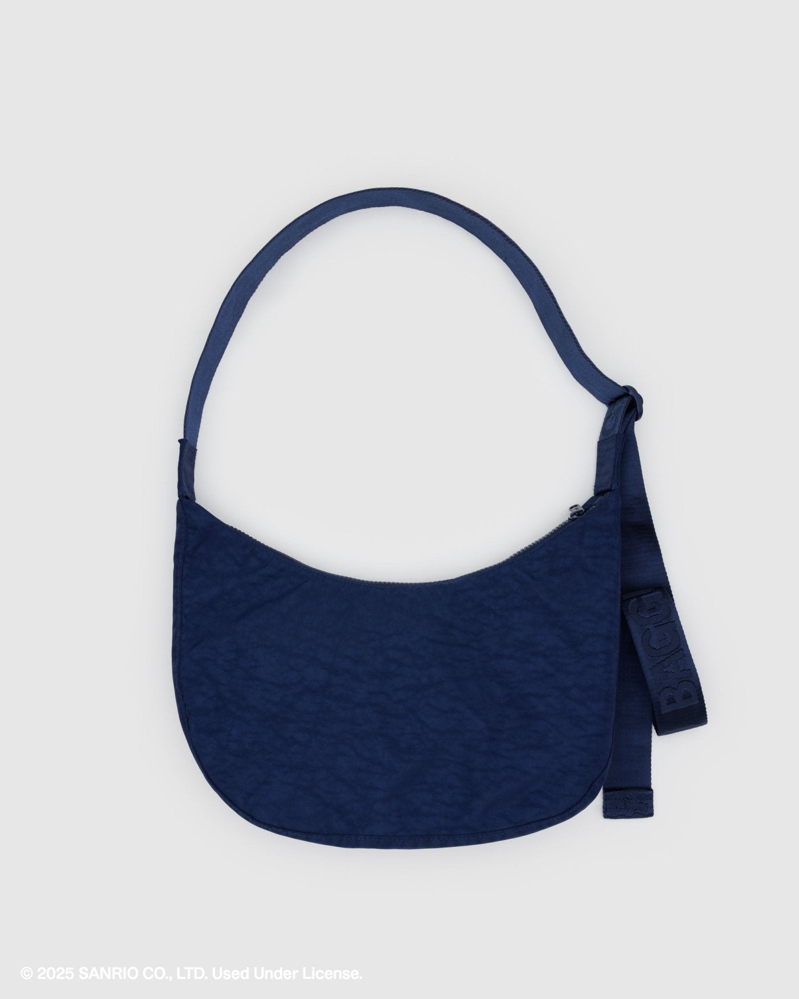 Back of navy blue crescent shoulder bag with tonal adjustable shoulder strap