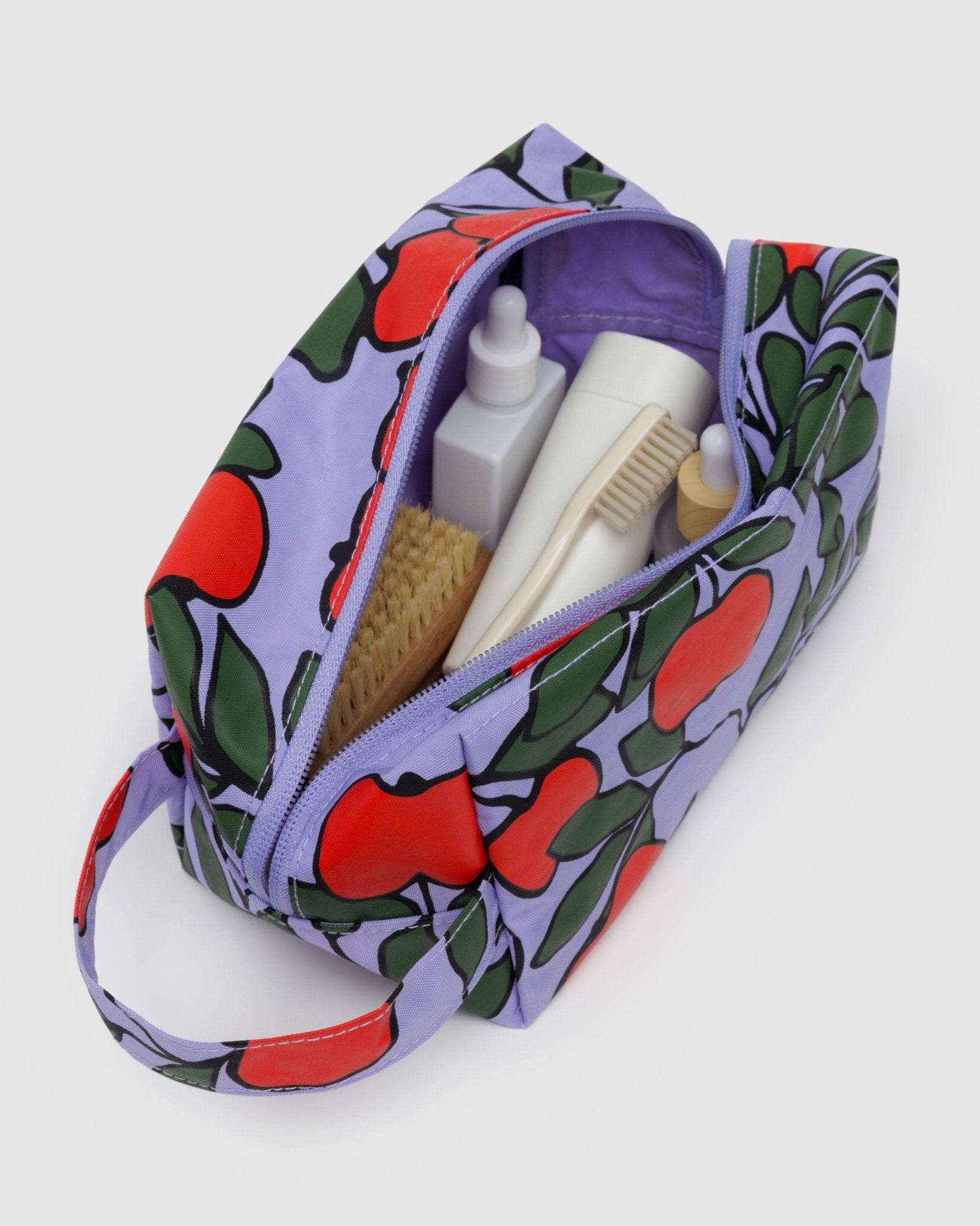 Wide zip open top rectangular bag with loop for carrying or hanging with three internal pockets and toiletries inside.
