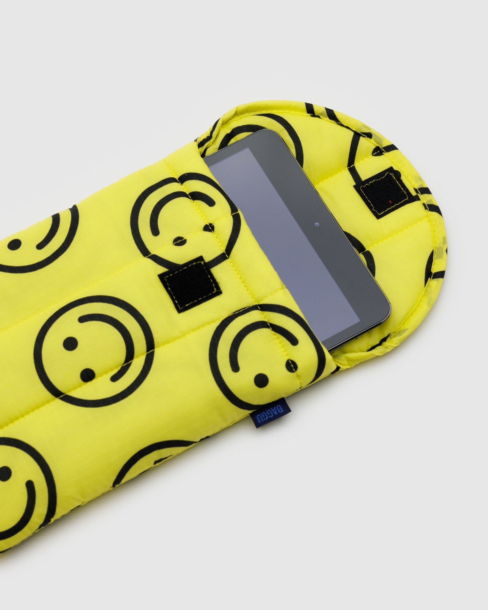 Tablet inside a Yellow with black happy face prints on a puffy and quilted tablet sleeve with velcro closure - ANNIE.G