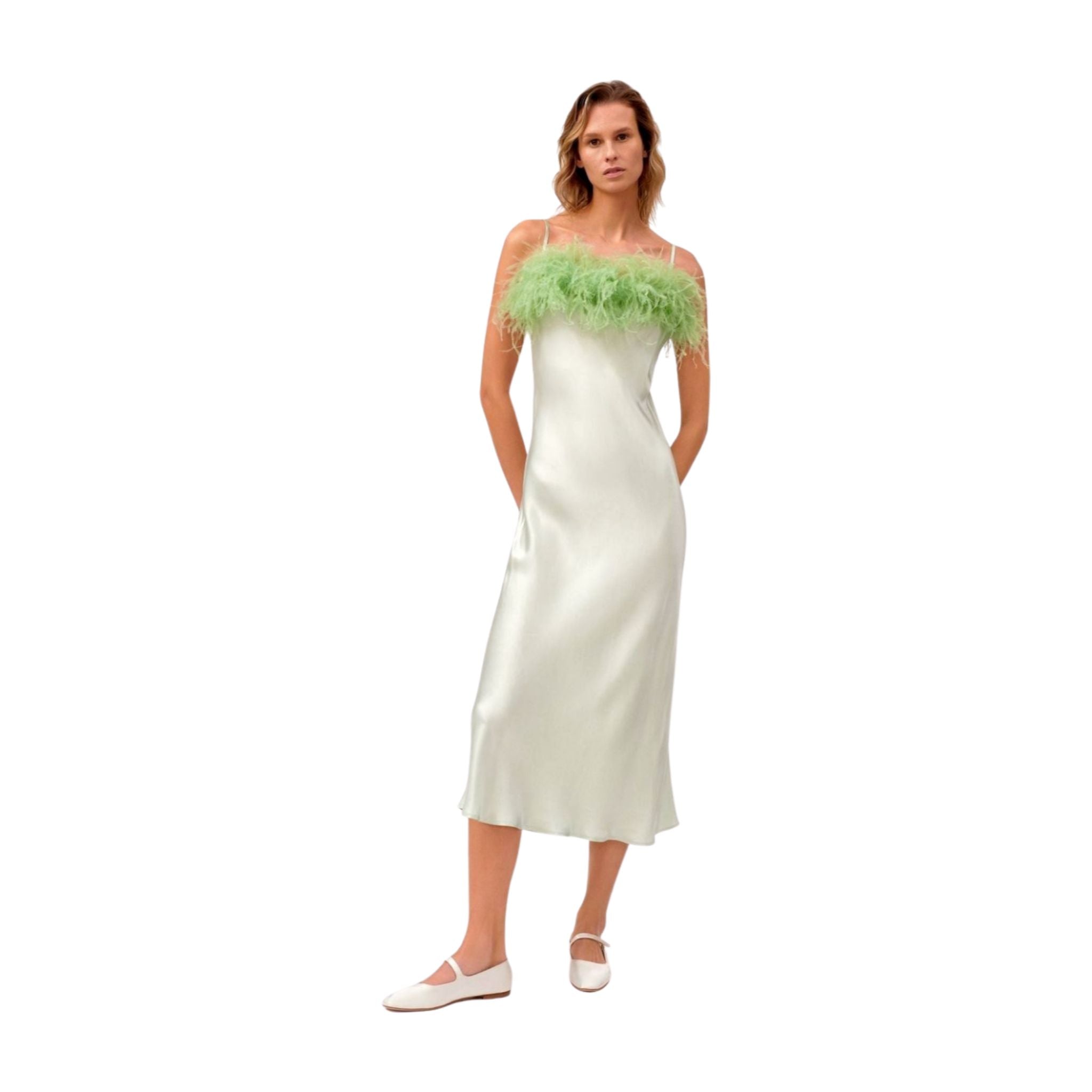 Woman wearing a mint slip dress with  spaghetti straps and green feather details around yoke.