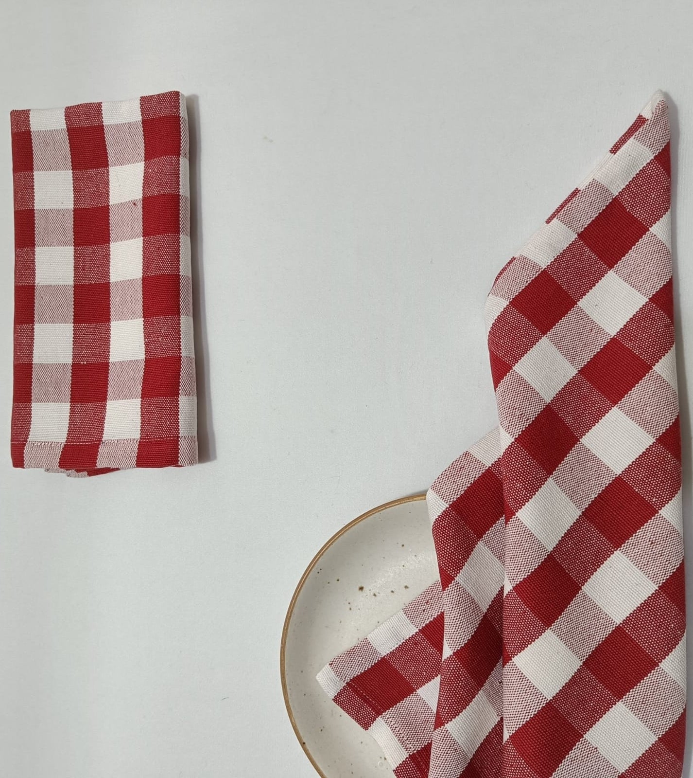 red-check-gingham-napkin-folded-and-another-across-a-plate