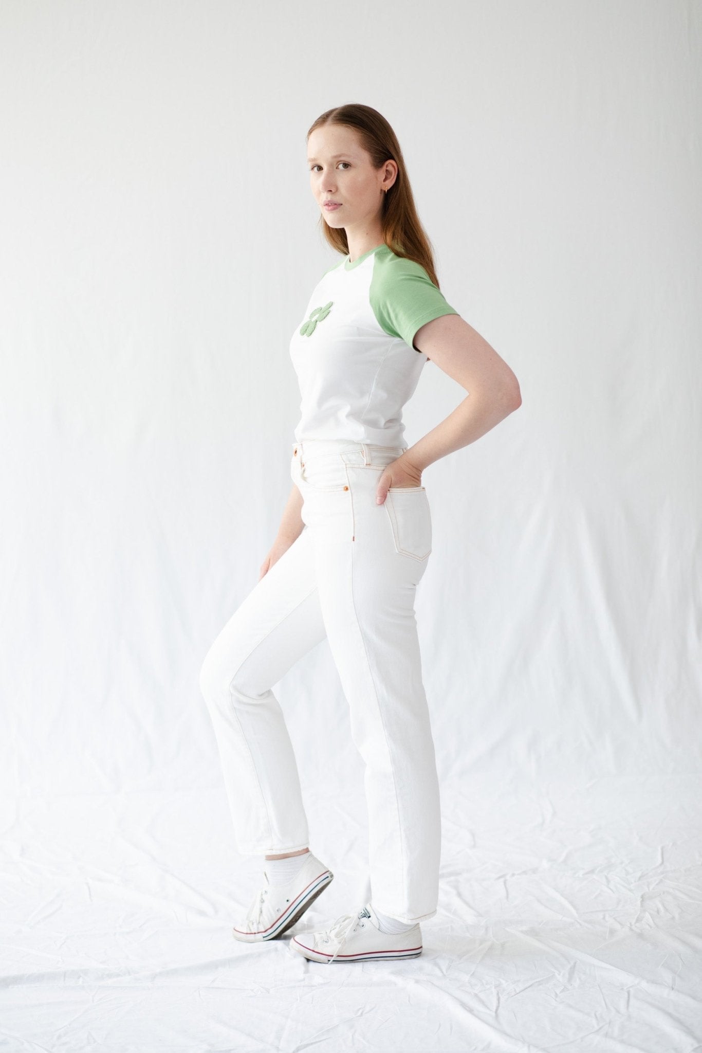 Woman wearing a white t-shirt with green sleeves and daisy on front - ANNIE.G