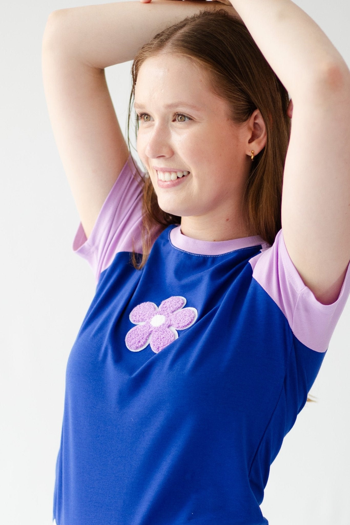 Lavender daisy on blue t-shirt with lavender crew neck and short sleeves - ANNIE.G