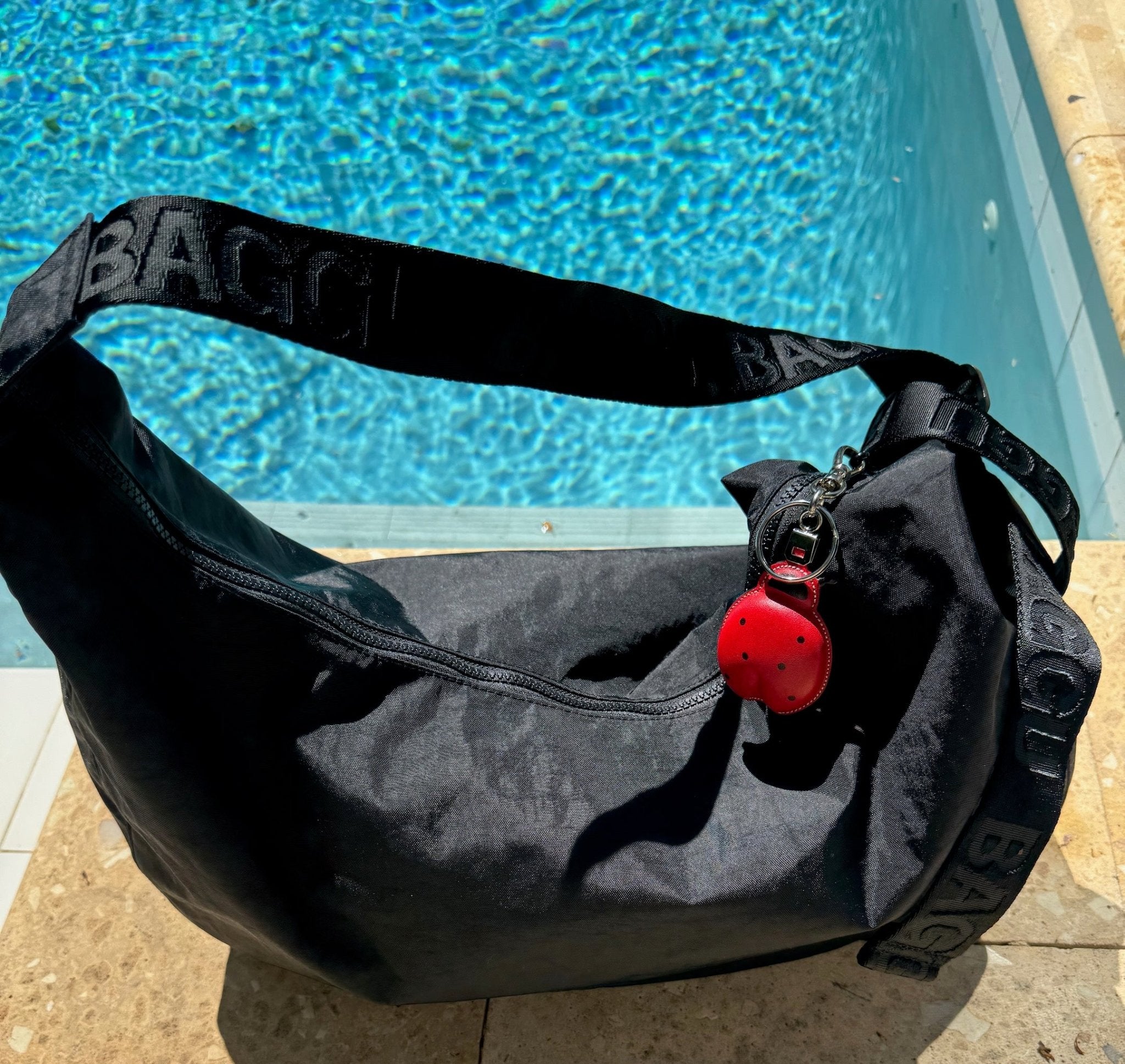 Red leather Ladybug Keychain Bag Charm on black bag near a pool - ANNIE.G