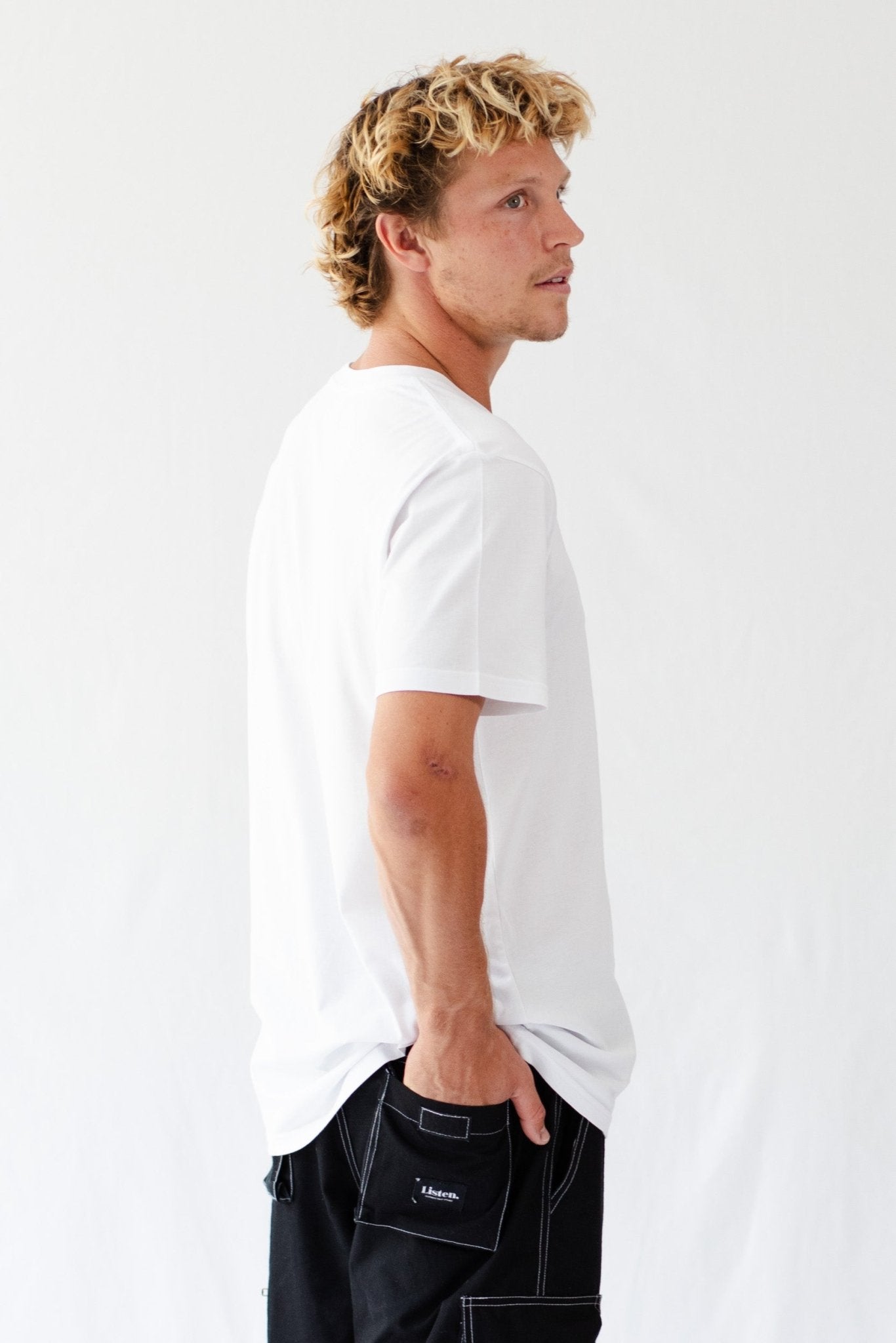 Back of a man wearing a white t-shirt with crew neck and short sleeves.