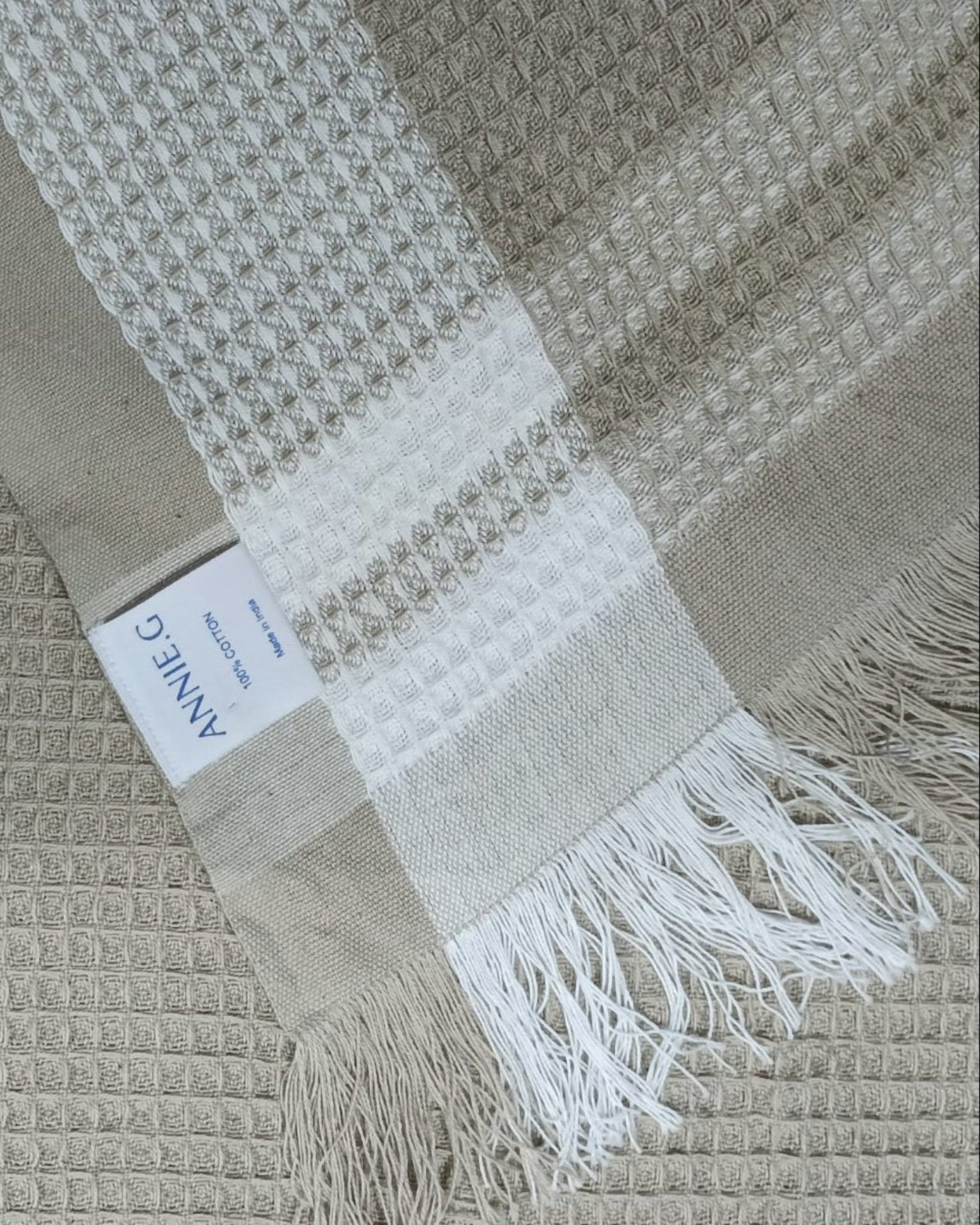 Bone towel with white border edges and fringe with ANNIEG brand label - ANNIE.G