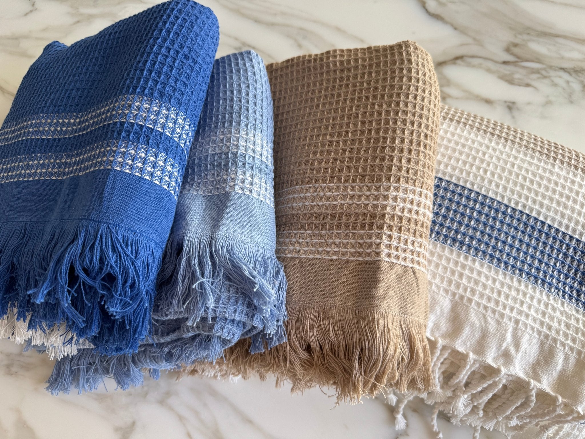 Folded stack of different coloured handwoven Waffle Towels with fringe - ANNIE.G