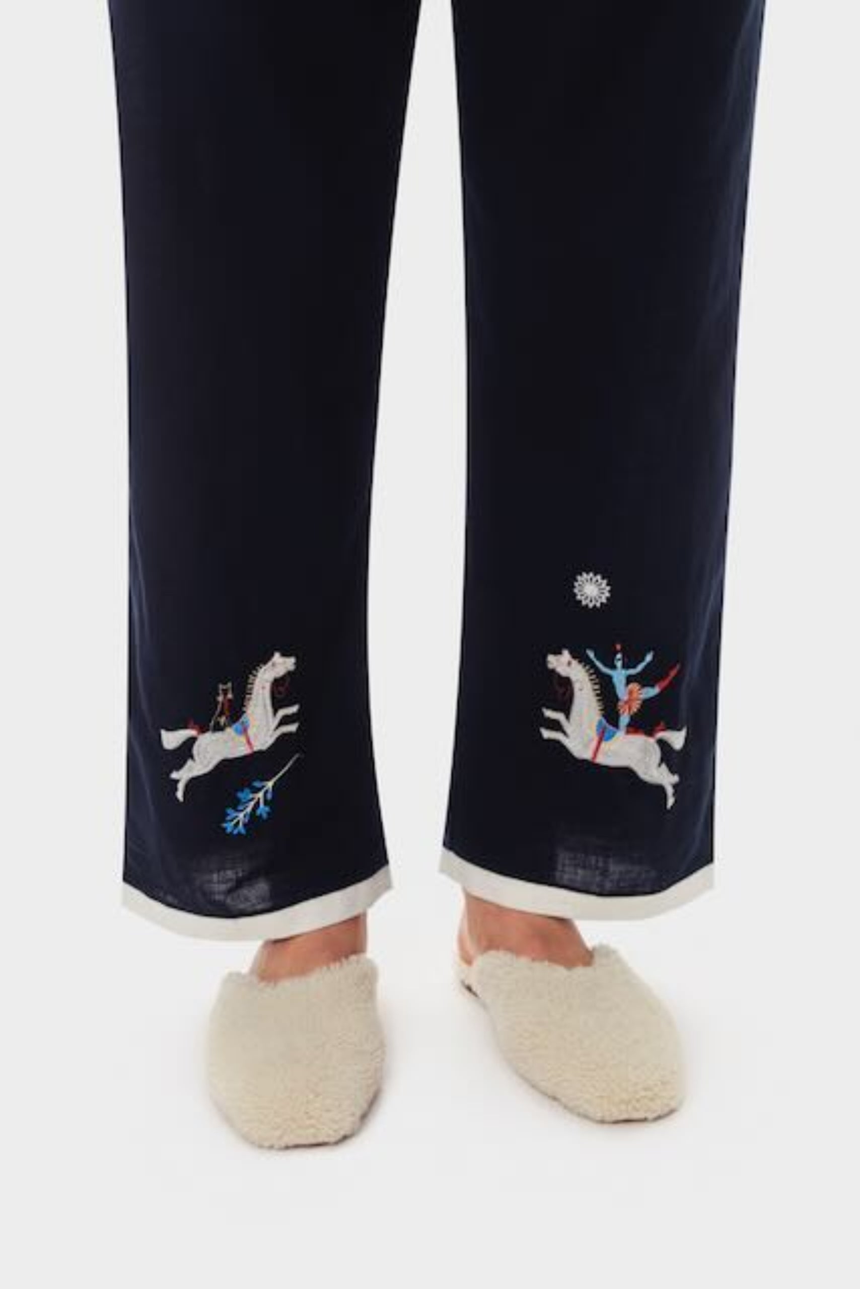 Person wearing navy embroidered long pants with cream slippers - ANNIE.G