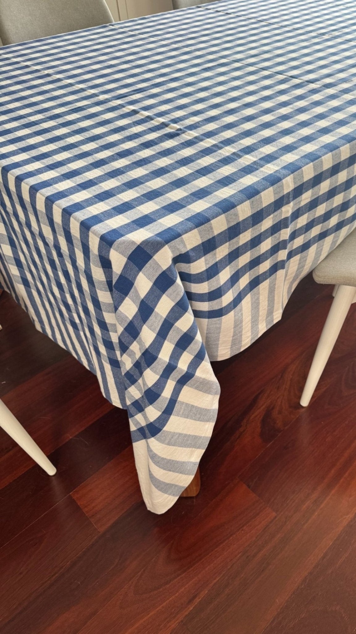 Rectangular blue and white checked tablecloth with hemmed edges laid on table inside - ANNIE.G