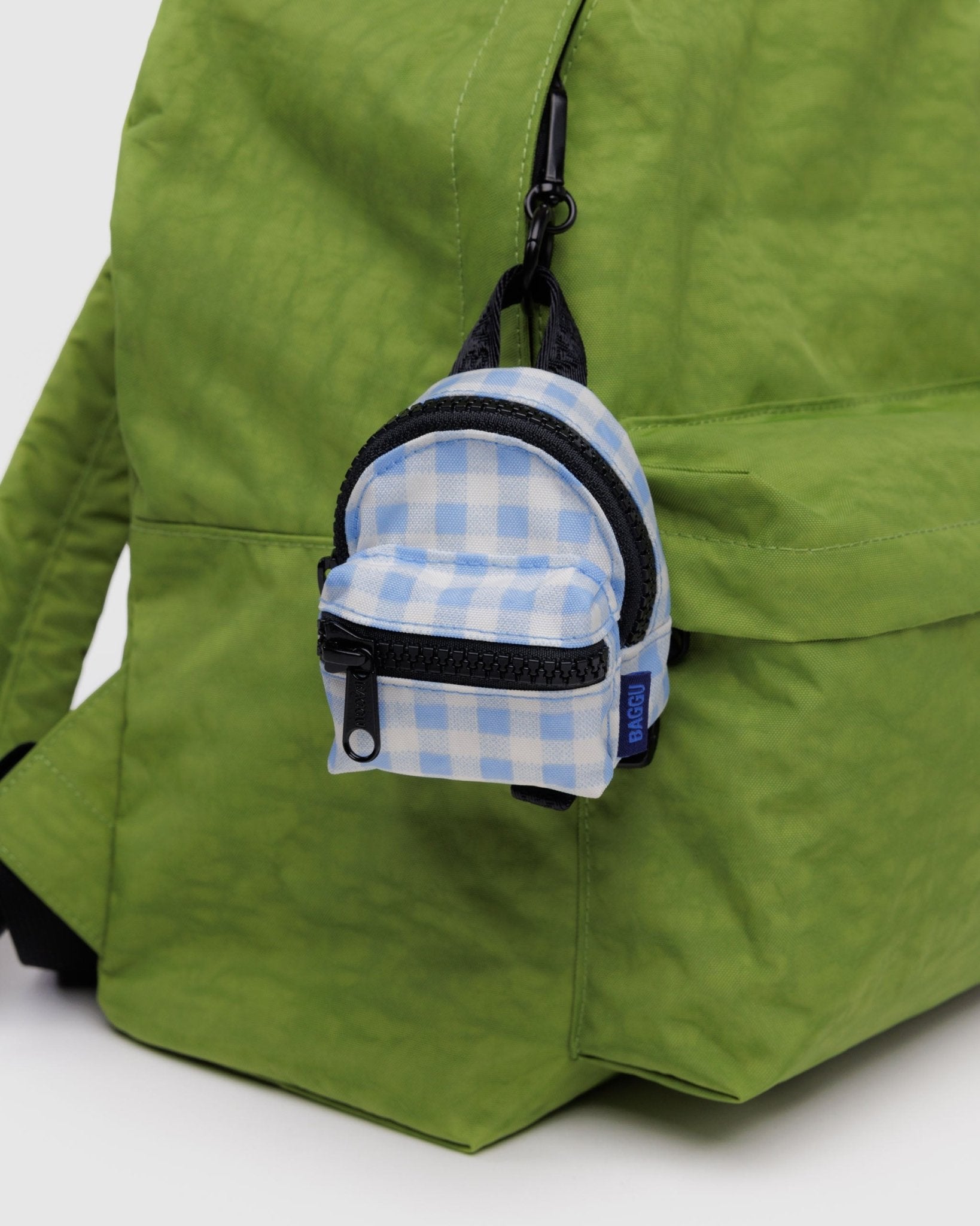 Light blue gingham Backpack Charm attached to green backpack zipper - ANNIE.G