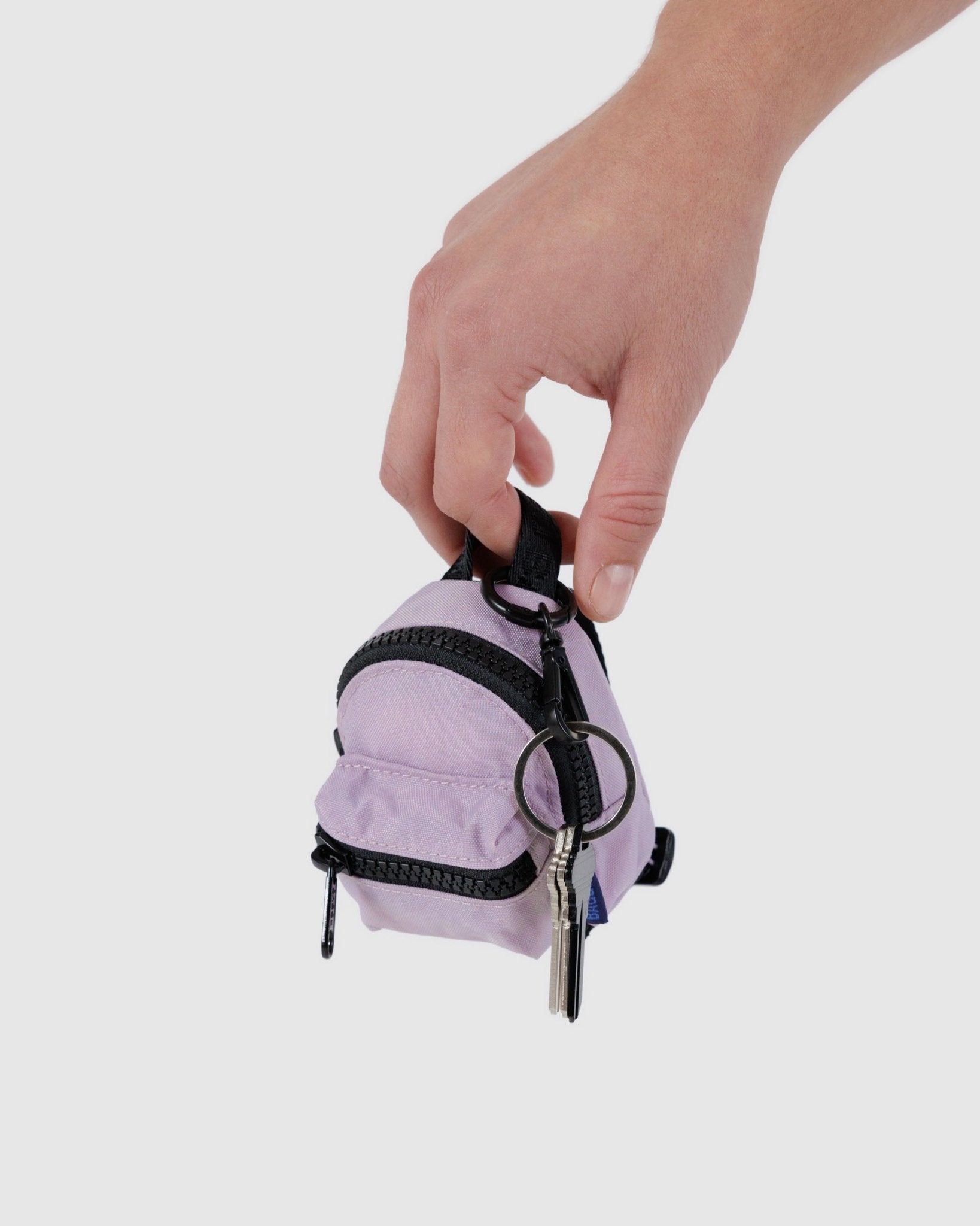 Persons hand holding a purple Backpack bag Charm with keys attached to keyring - ANNIE.G