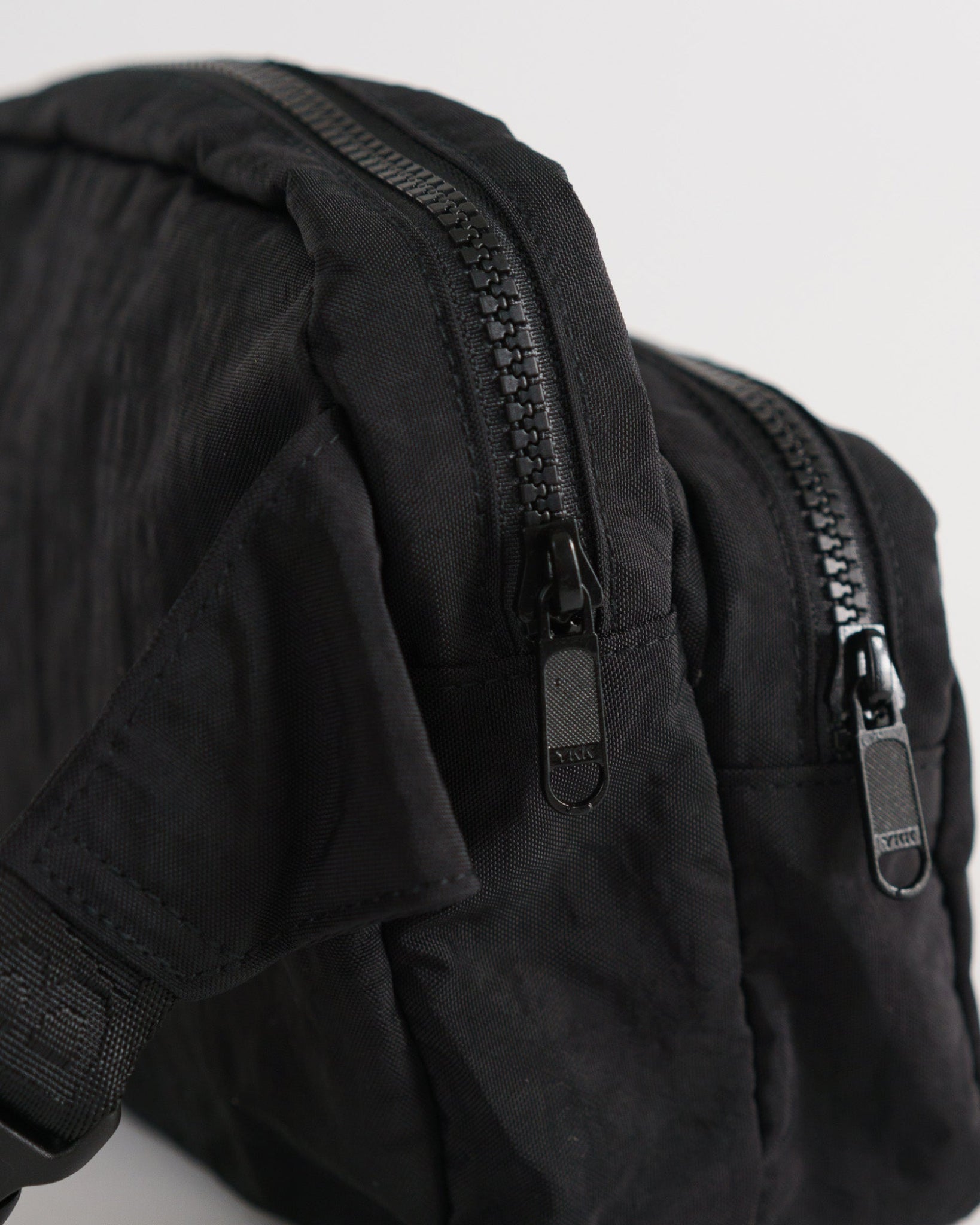 Two zip compartments on the black fanny pack.