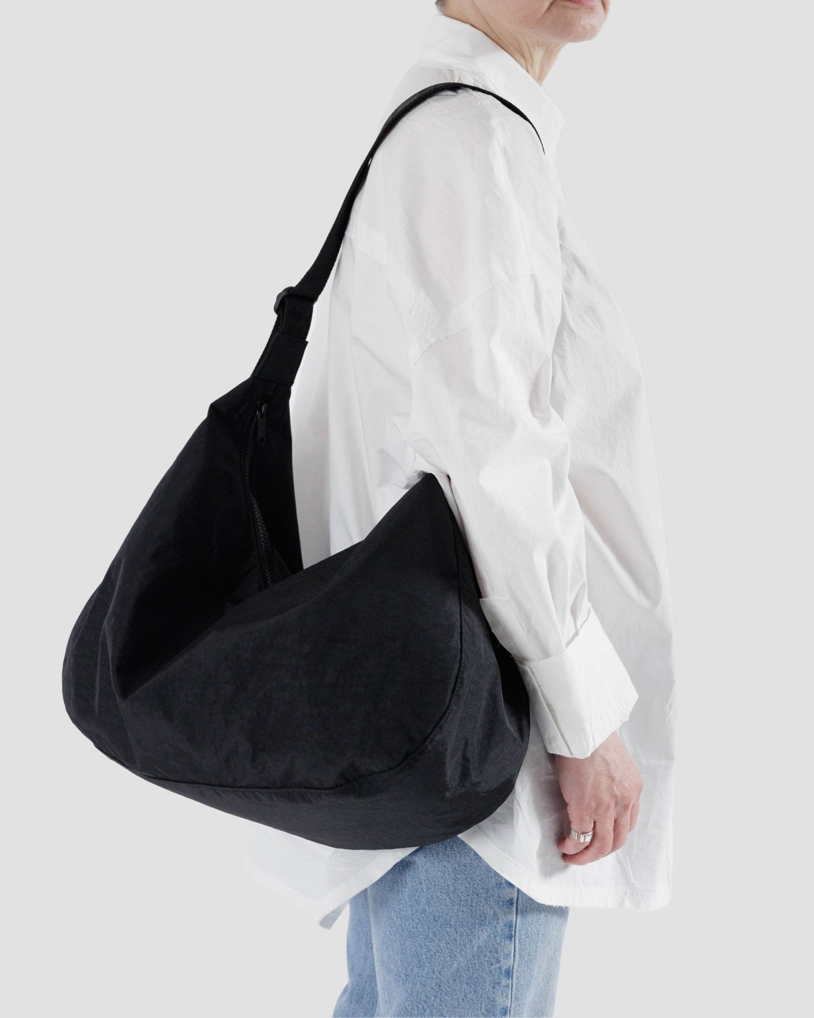 Person wearing the large black crescent bag on shoulder - ANNIE.G