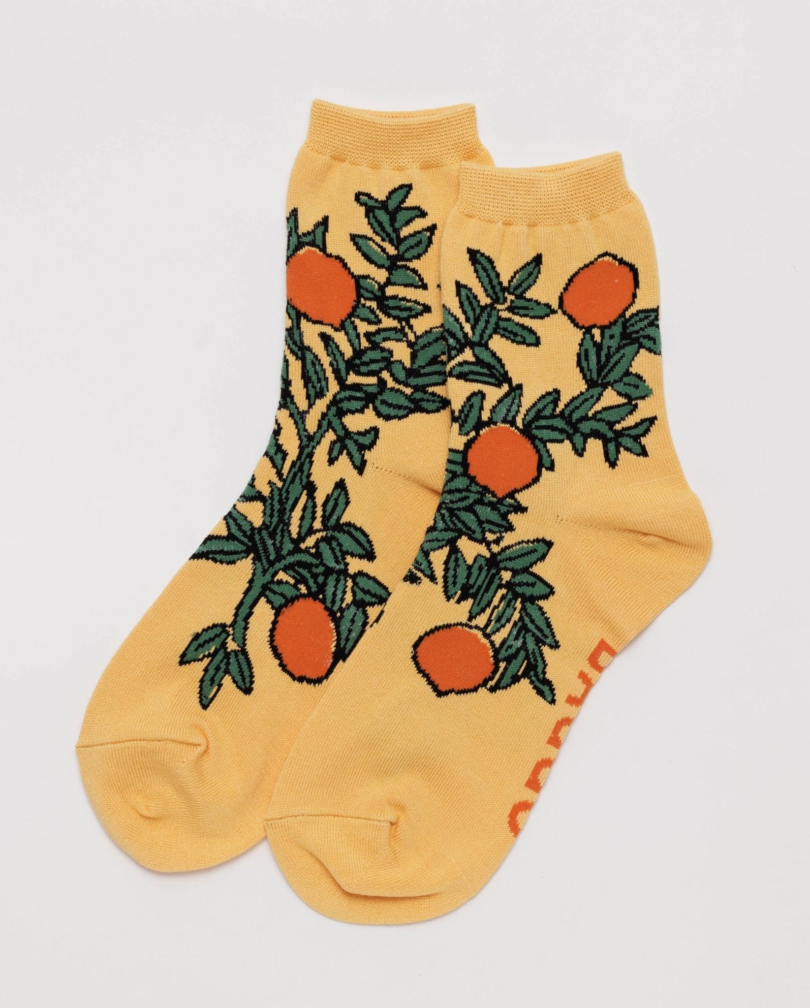 Yellow crew socks with oranges and green leaves pattern.