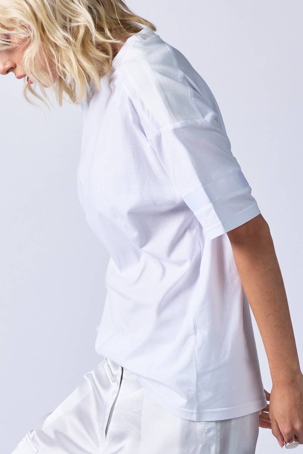 woman wearing white relaxed t-shirt with white grosgrain ribbon around sleeve