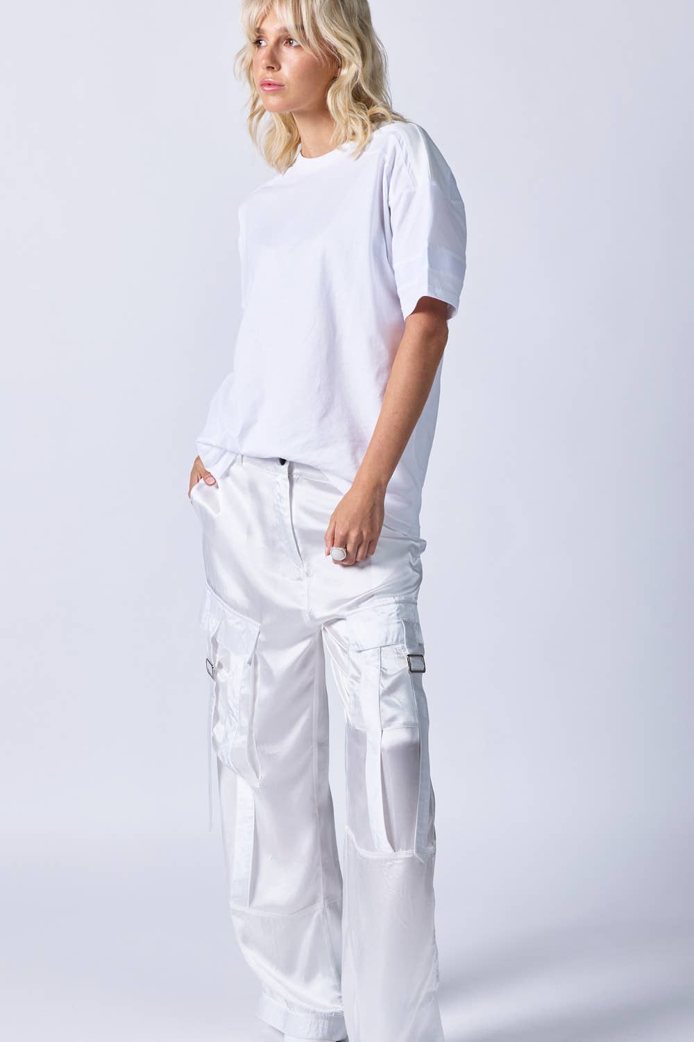 Front view of woman wearing white jeans and white t-shirt with grosgrain ribbon detail around sleeve