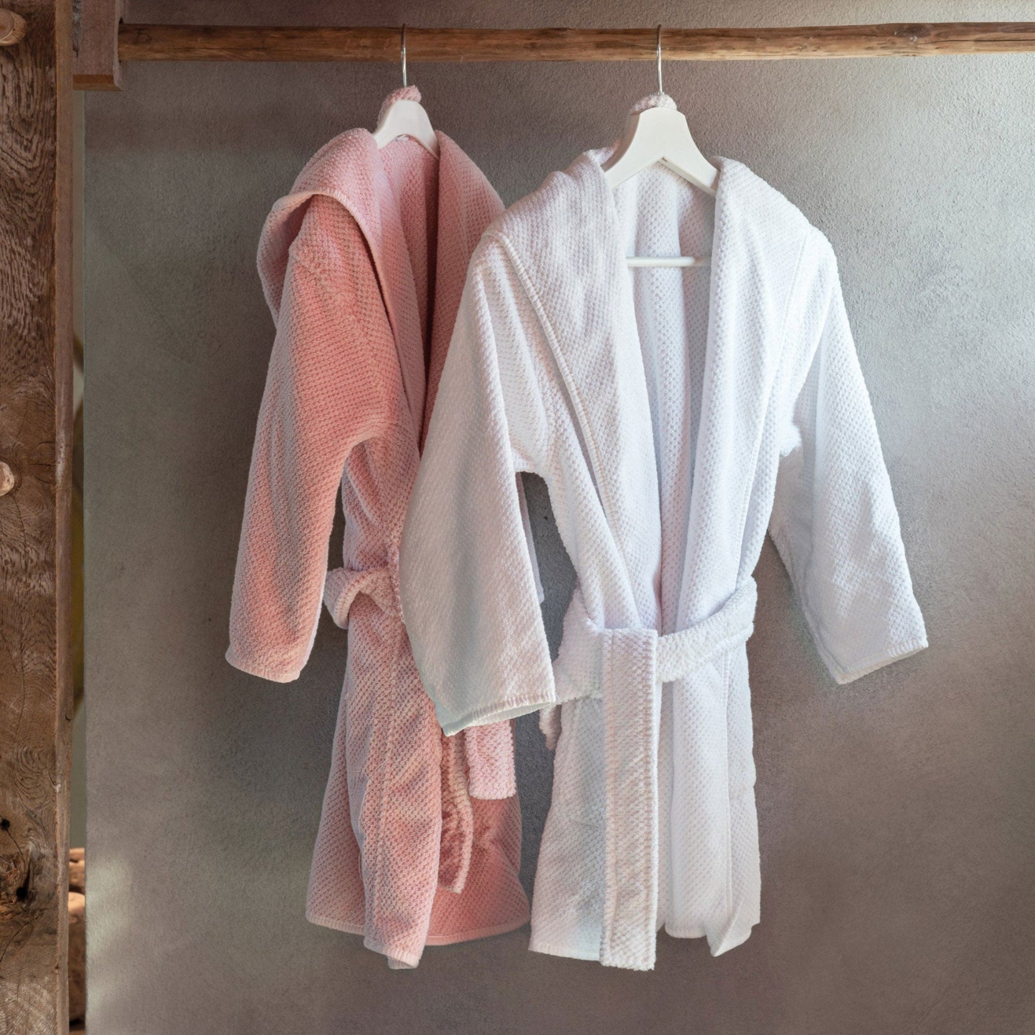 pink and white hanging kids bath robe with matching belt.